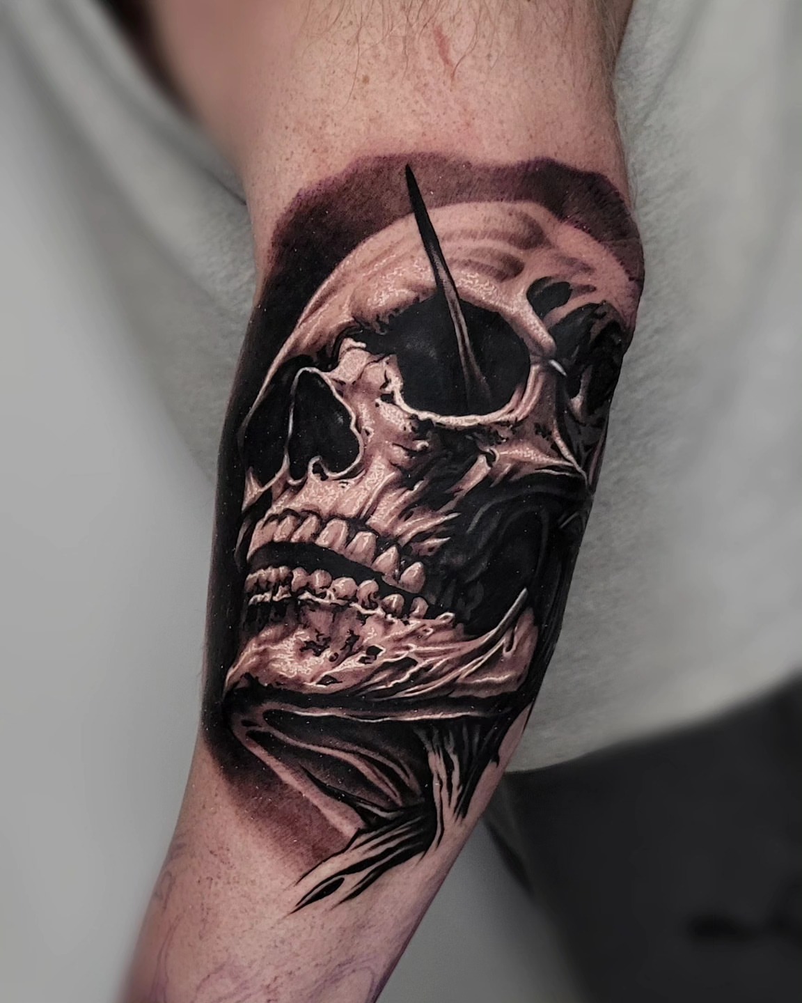 Skull dark realism tattoo on the forearm by Lukasz Olszanski