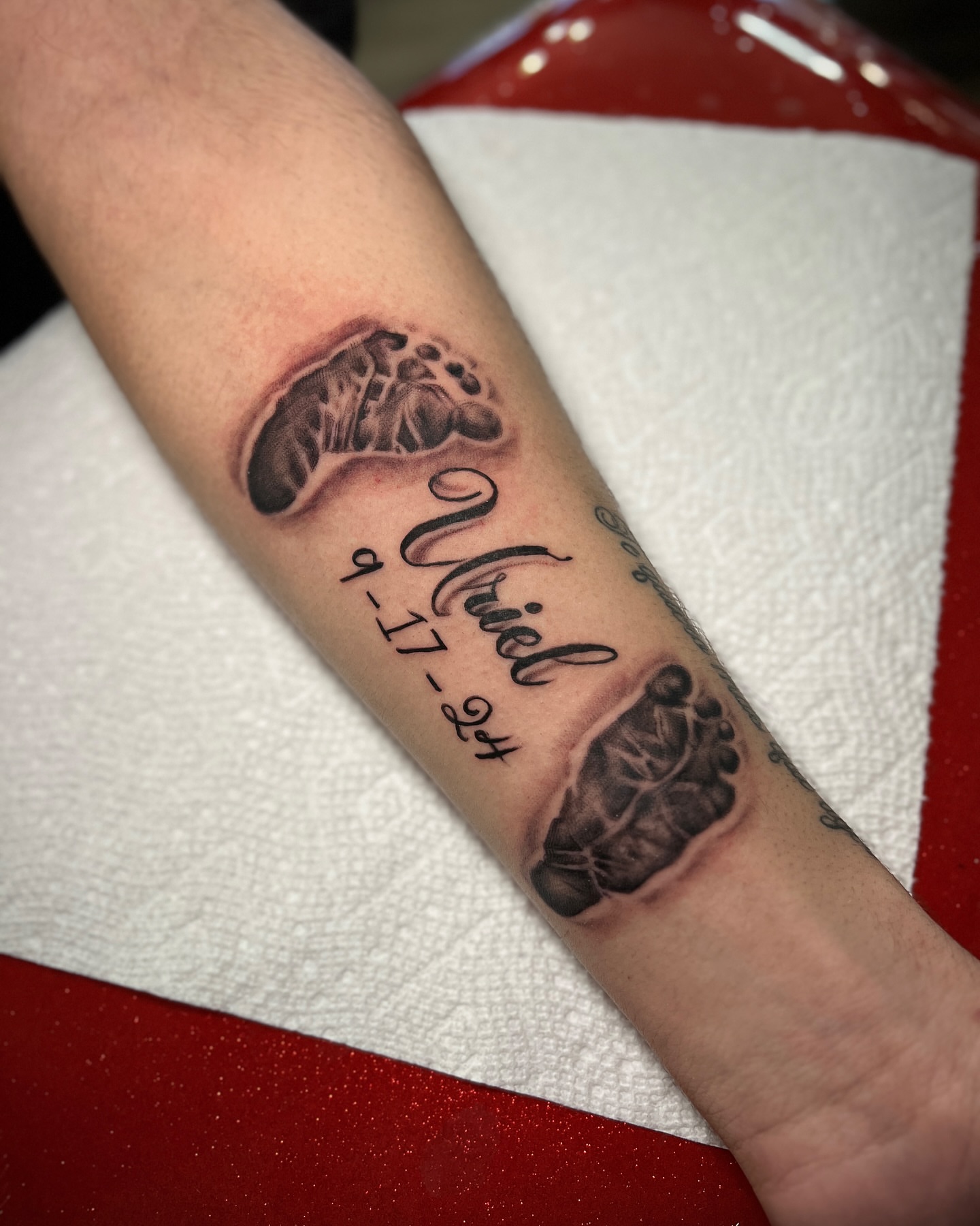Baby footprints and name realism tattoo on the forearm by Lucky Valenzuela, Lakewood, Colorado