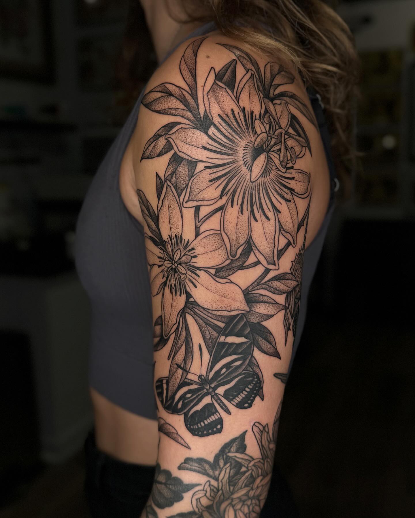 Flowers and butterfly dotwork tattoo on the upper arm by Kyle Stacher - Blackwork Tattoos - Denver