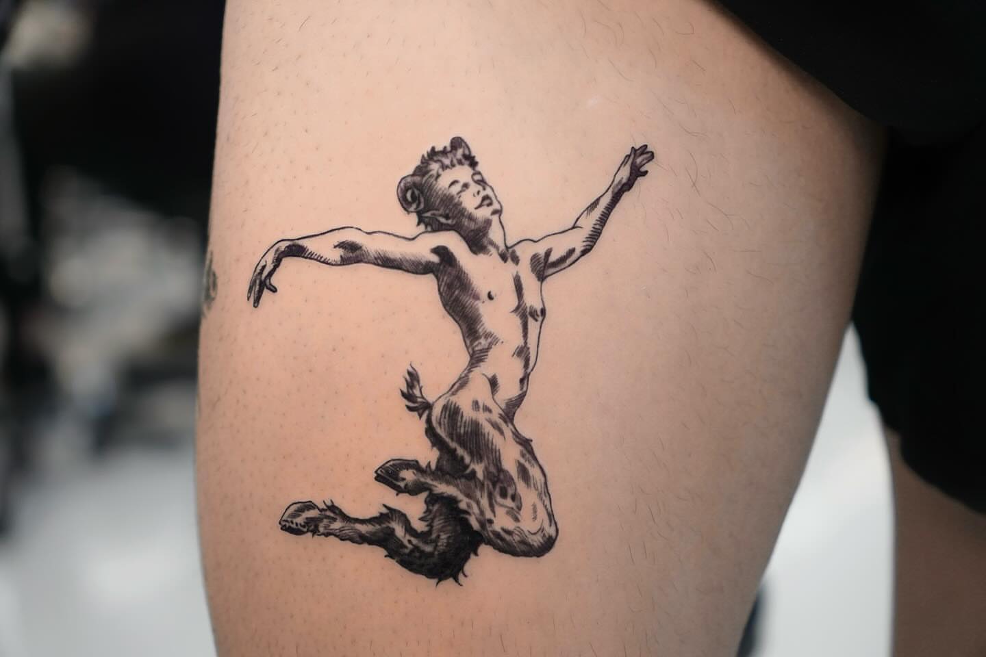 Naked man jumping black and grey tattoo on the thigh by David H.