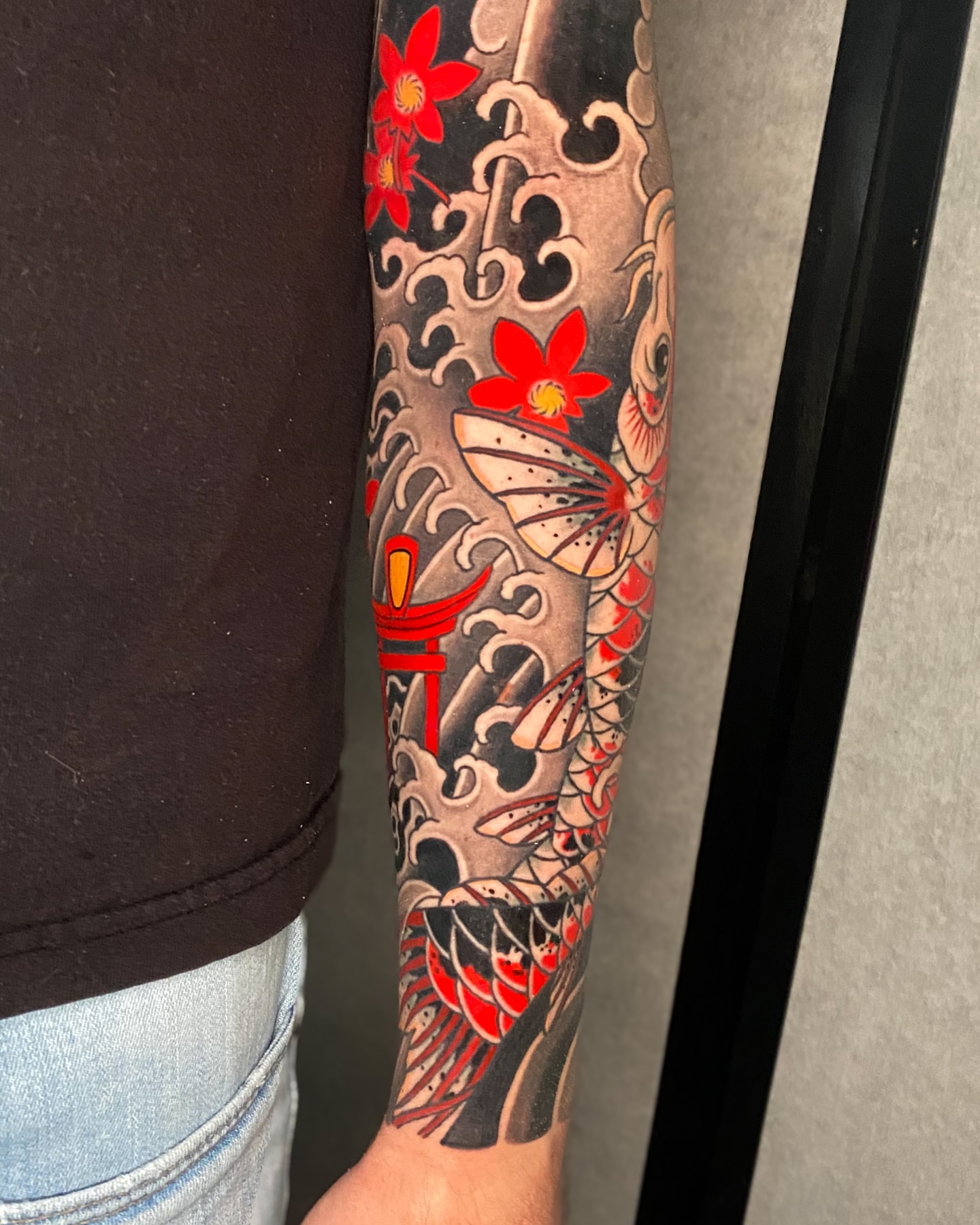Koi fish and flowers japanese irezumi tattoo on the forearm by Mitch Bonifay