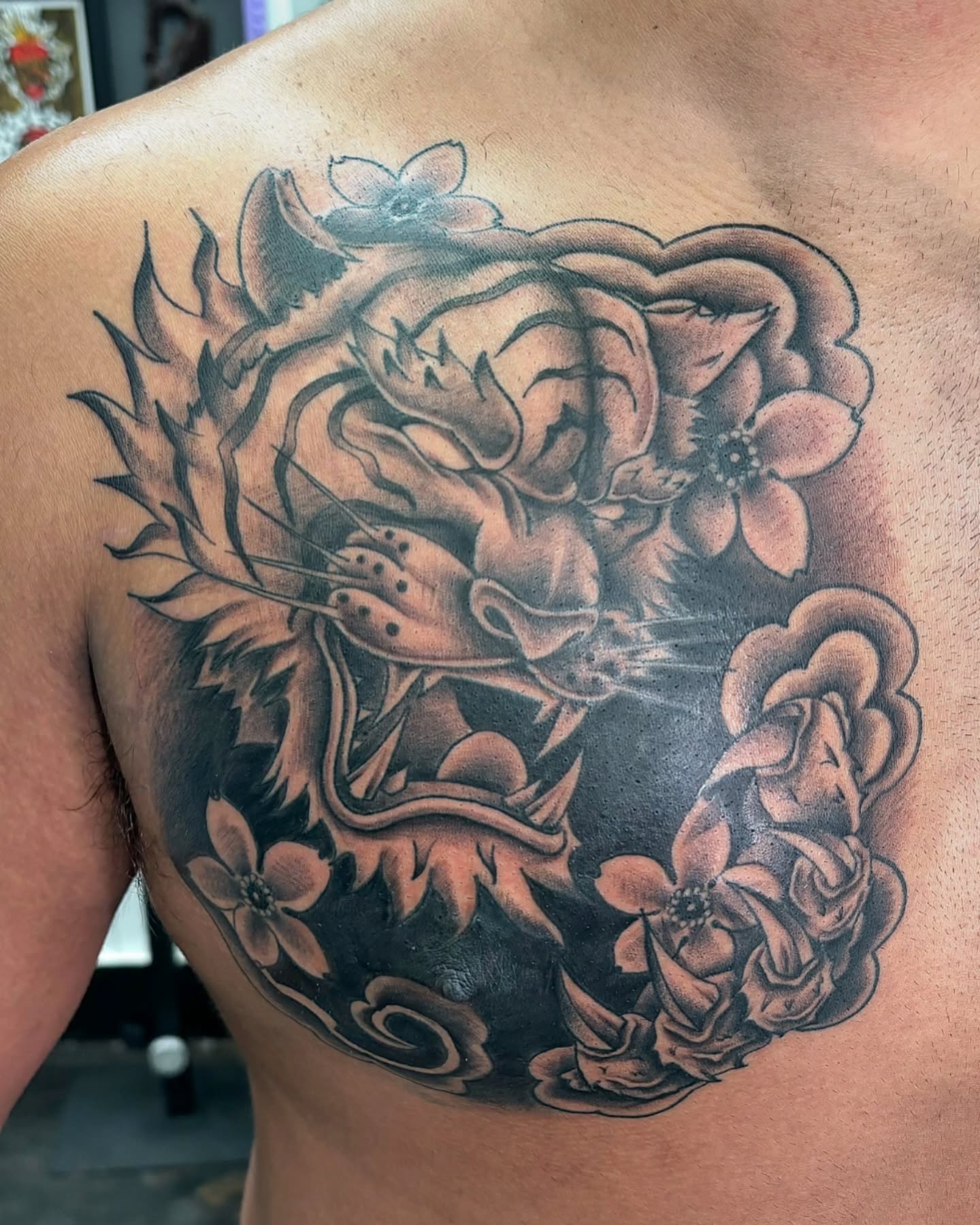 Lion and flowers black and grey tattoo on the chest by @seibastattoos, Virginia Beach, Virginia
