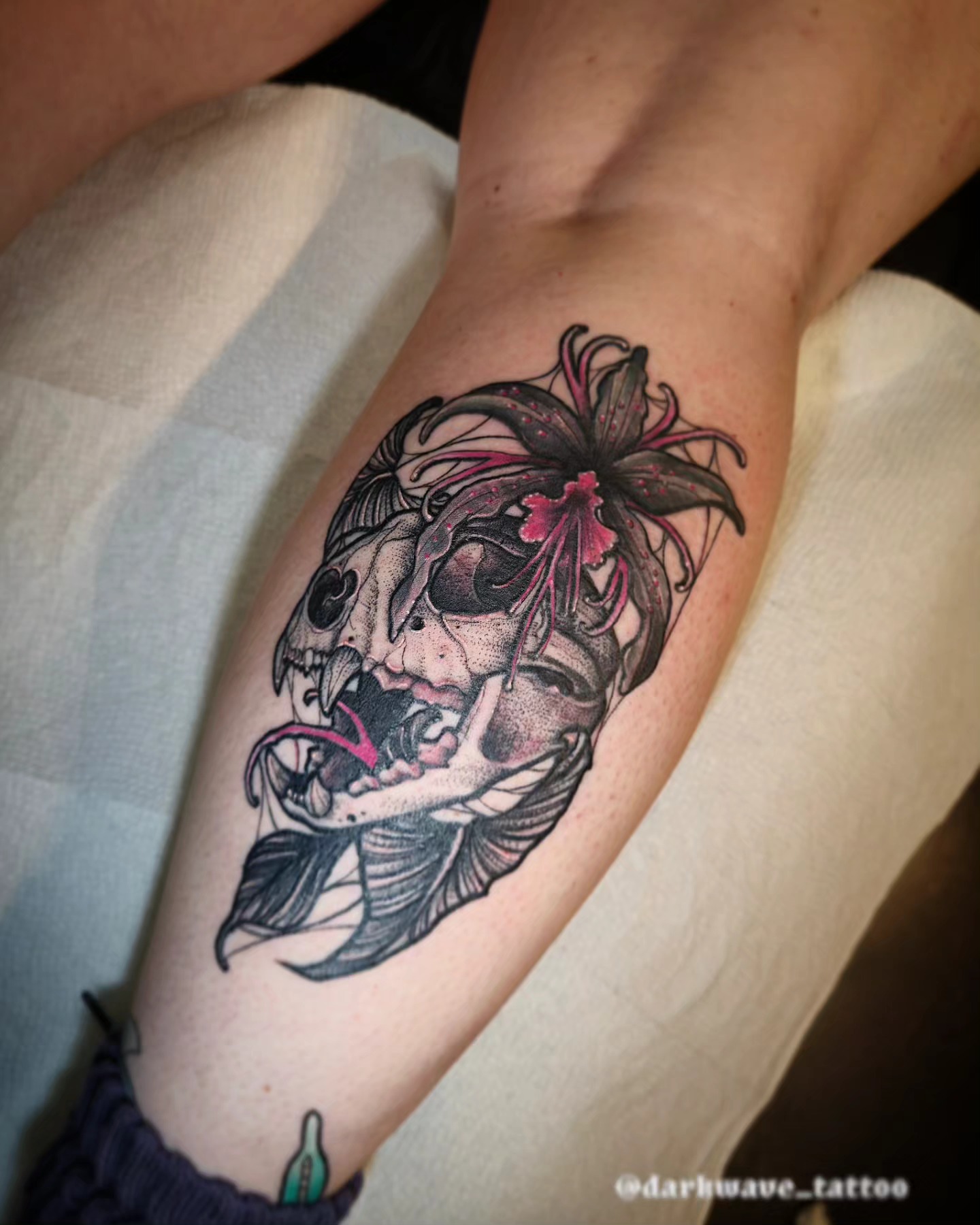 Skull with flowers dark realism tattoo on the forearm by Barrett Handel