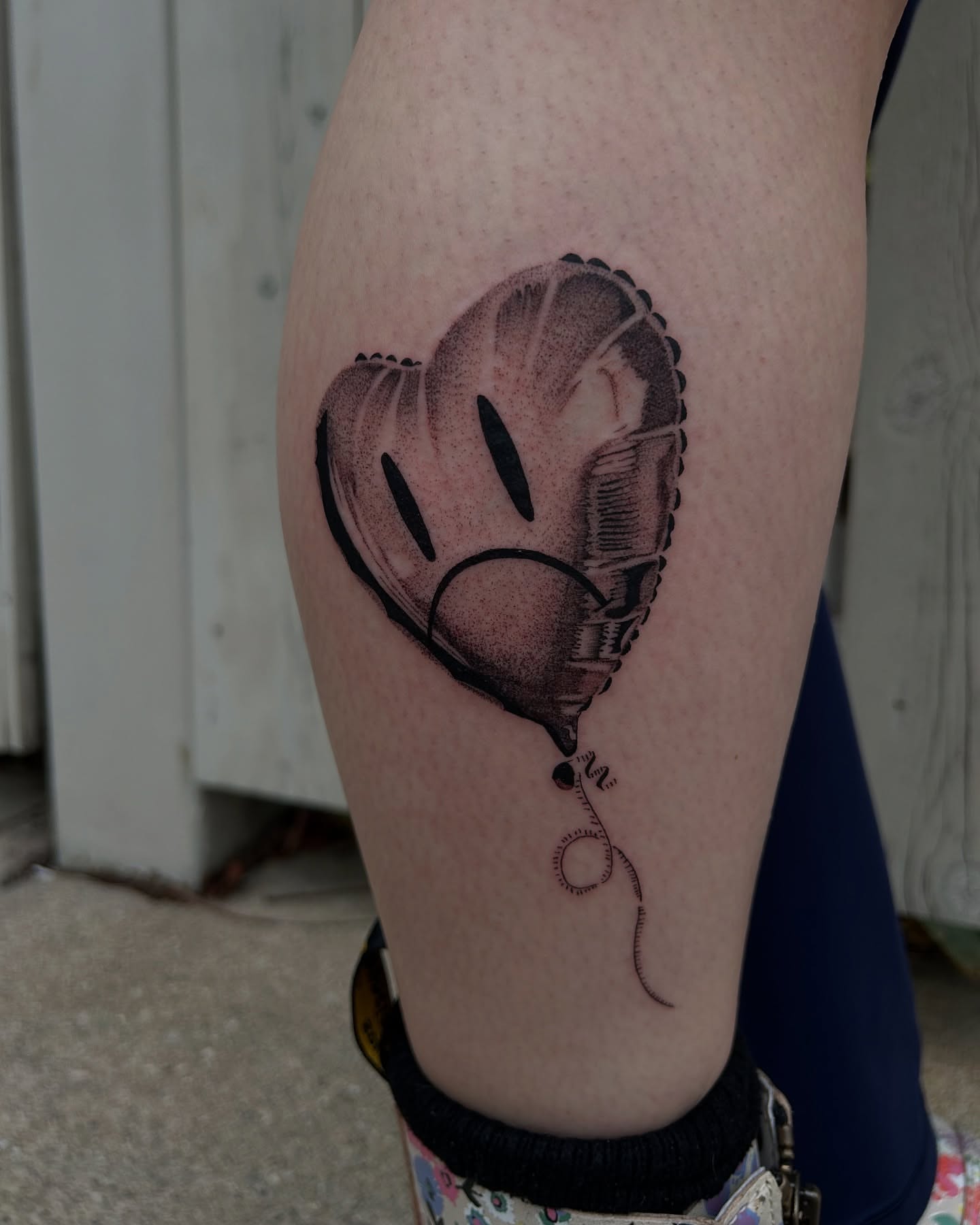 Heart-shaped balloon dotwork tattoo on the thigh by Kennedy Ramey