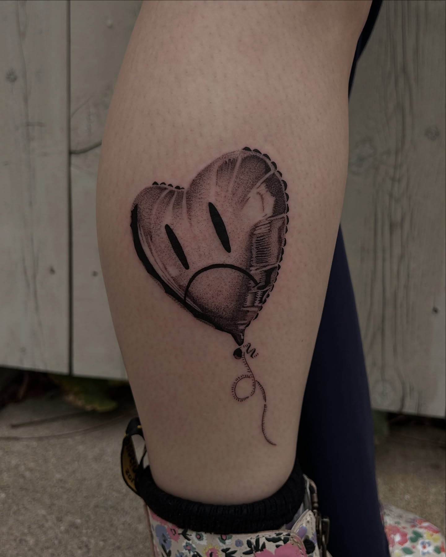 Sad heart balloon dotwork tattoo on the thigh by Kennedy Ramey