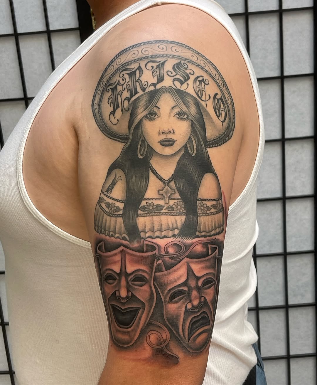 Woman in sombrero with theater masks Chicano tattoo on the shoulder by Mister Joe Joe Frisco Tattoo, San Francisco, California