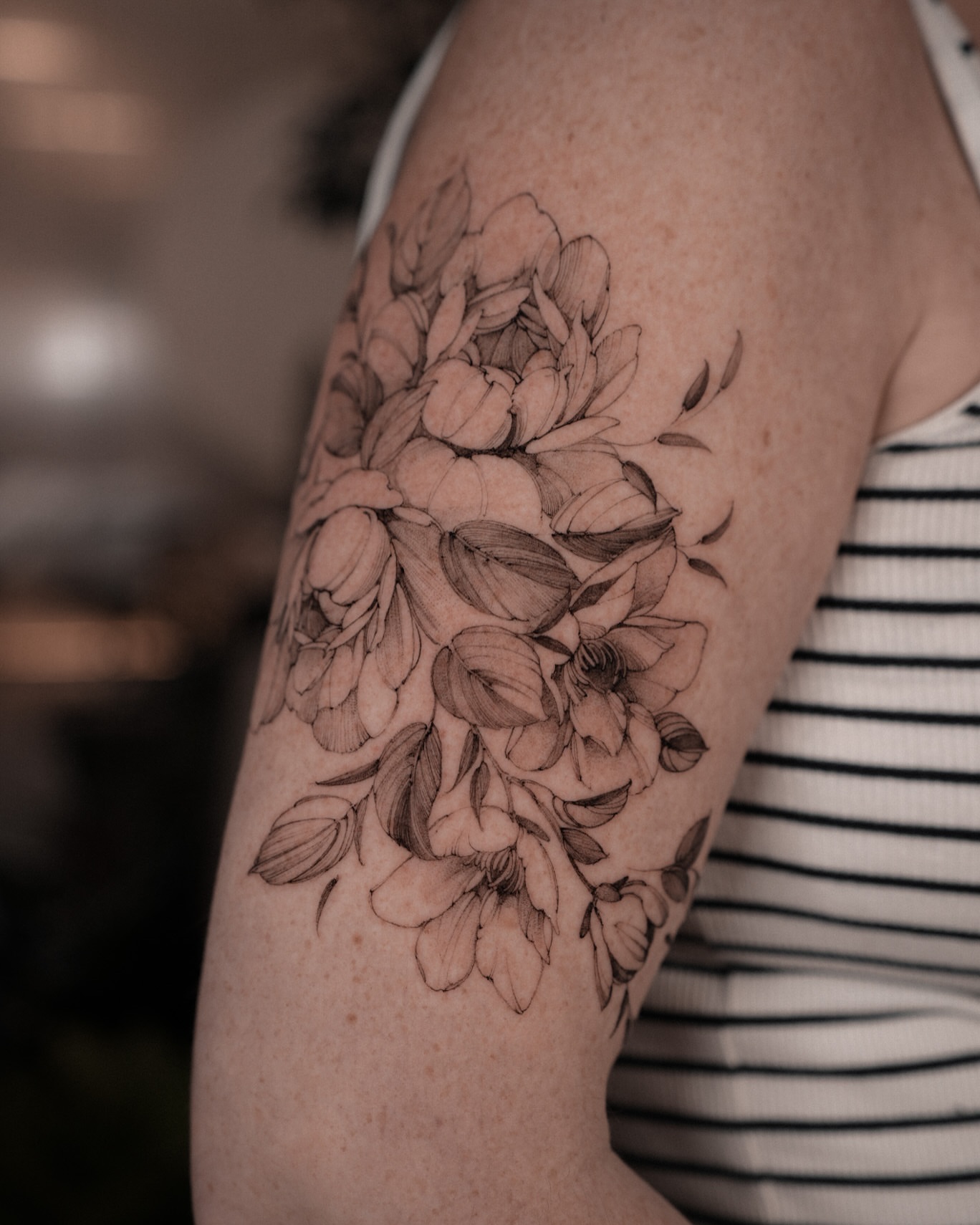 Floral bouquet black and grey tattoo on the upper arm by Mary Shekh