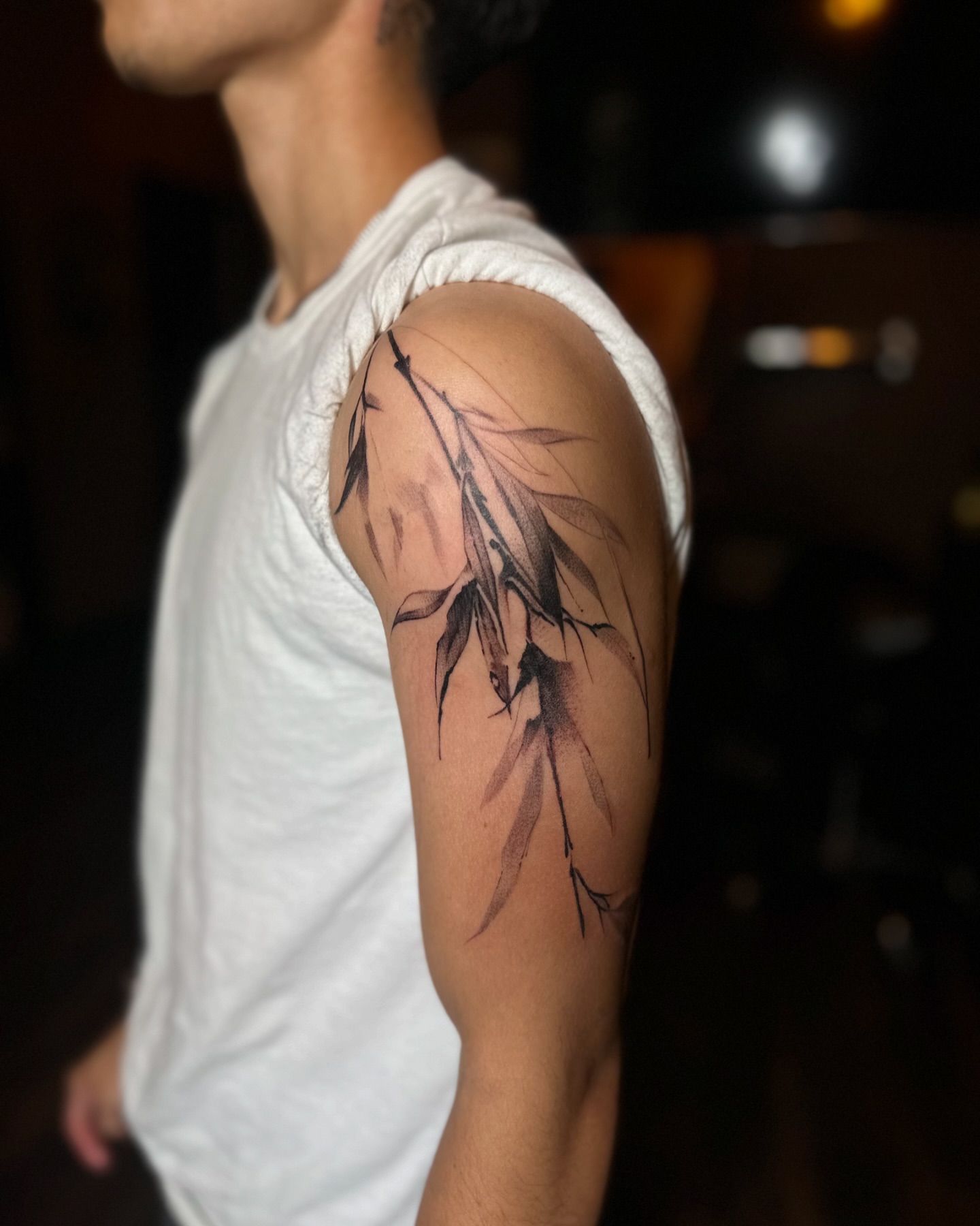 Bamboo leaves black and grey tattoo on the upper arm by Jevon Glasco Tattoos