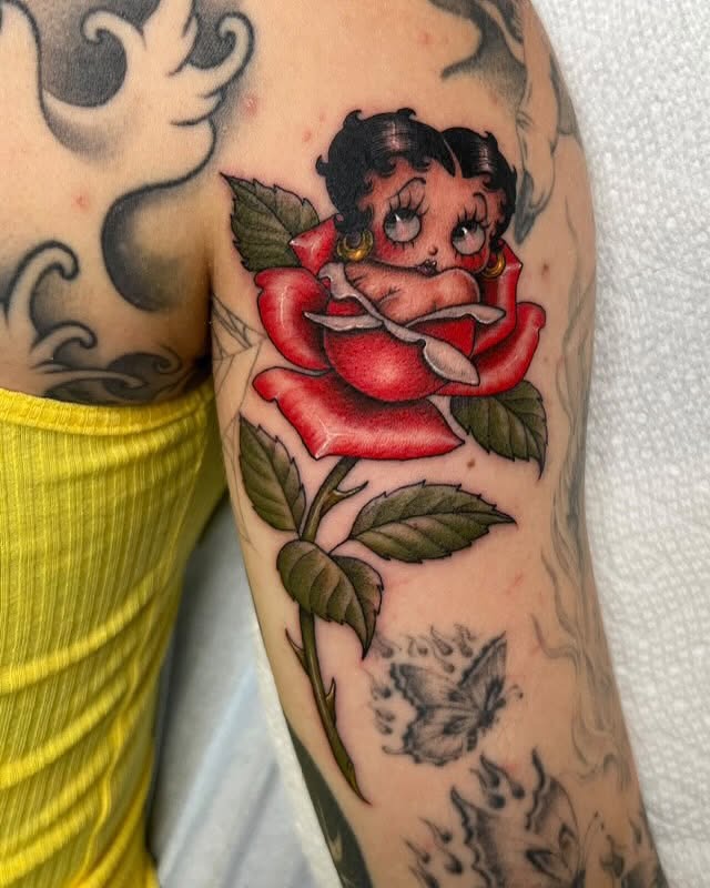 Betty Boop in a rose American traditional tattoo on the forearm by Valerie Dominguez