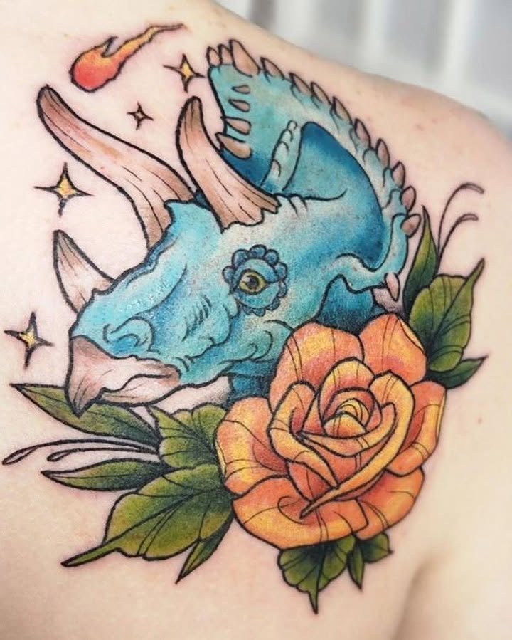 Triceratops and rose American traditional tattoo on the shoulder by Audrey Luther