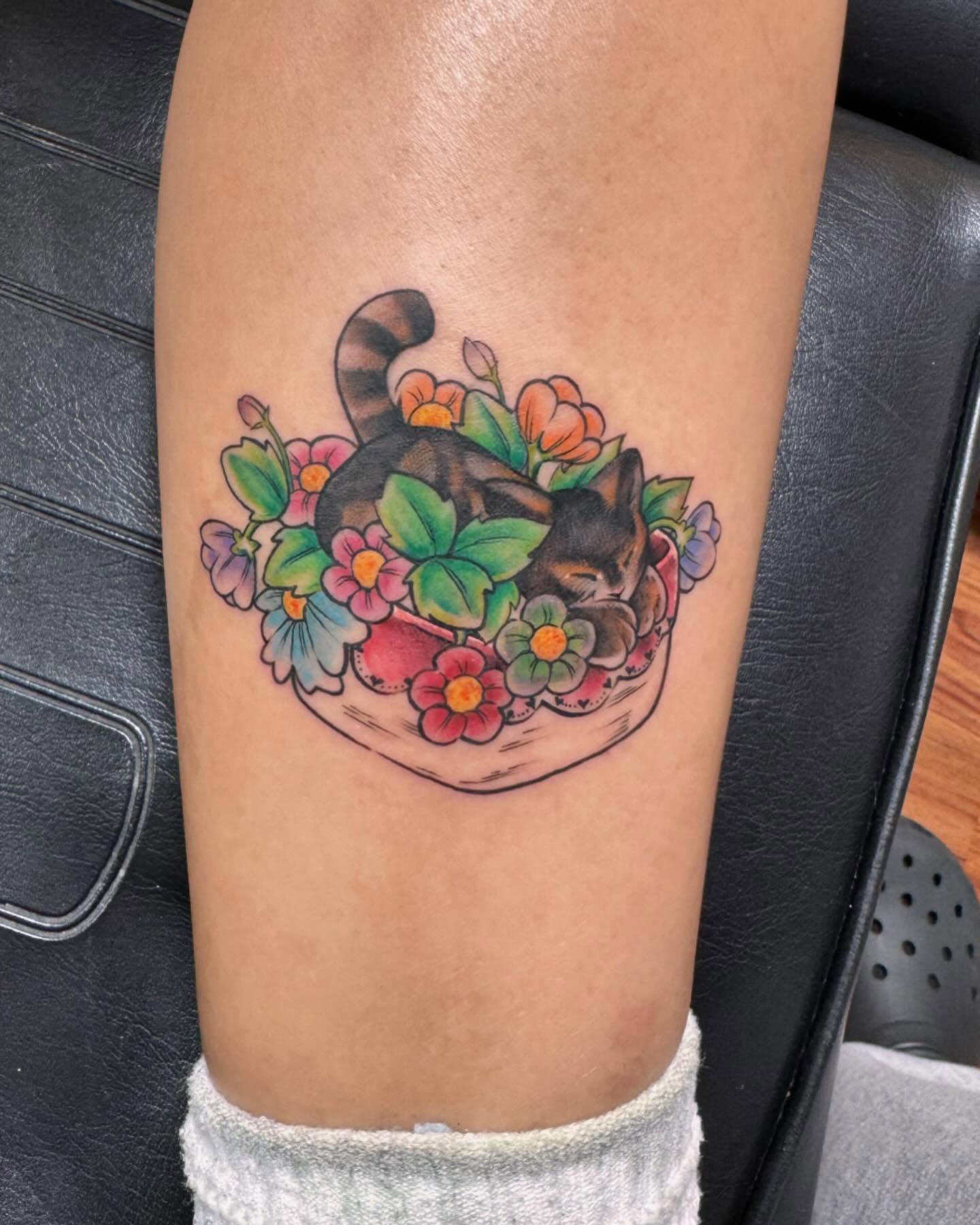 Cat in floral basket new school tattoo on the forearm by Jan Xander