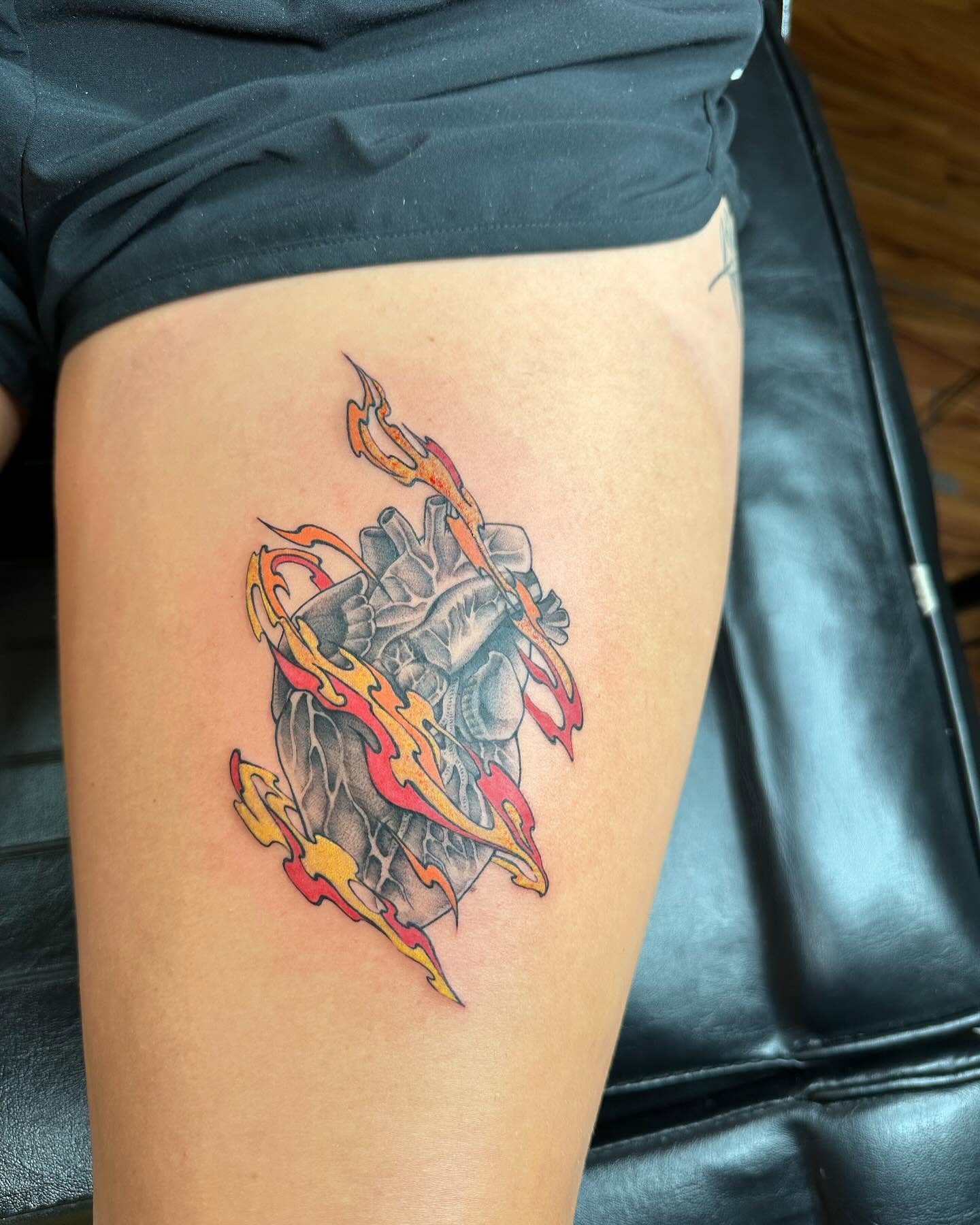 Flame and heart American traditional tattoo on the thigh by Jan Xander