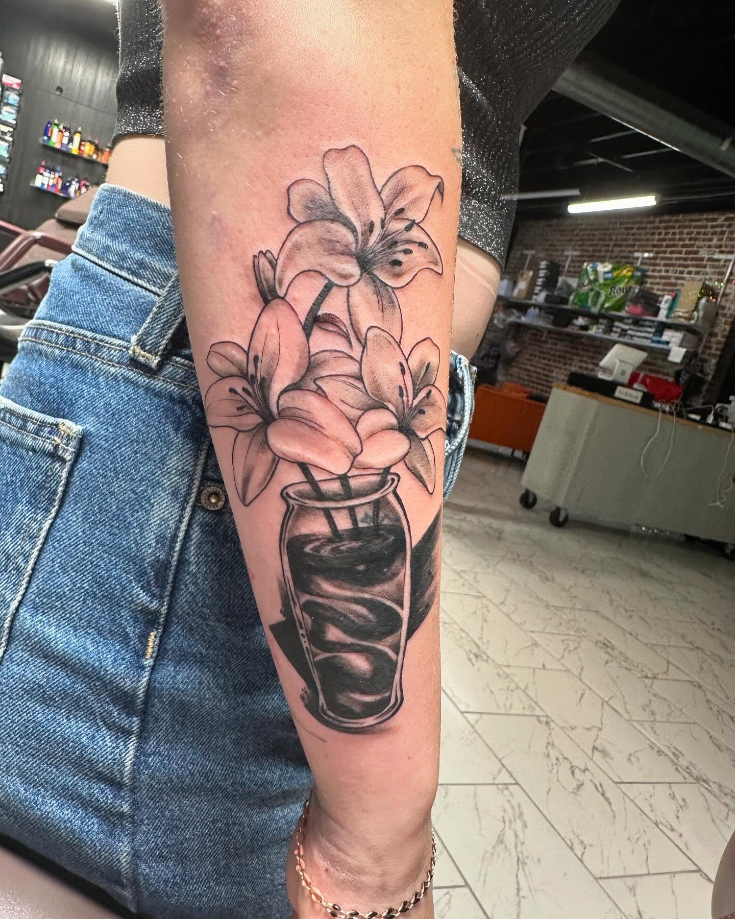Flowers in a jar black and grey tattoo on the forearm by Jan Xander