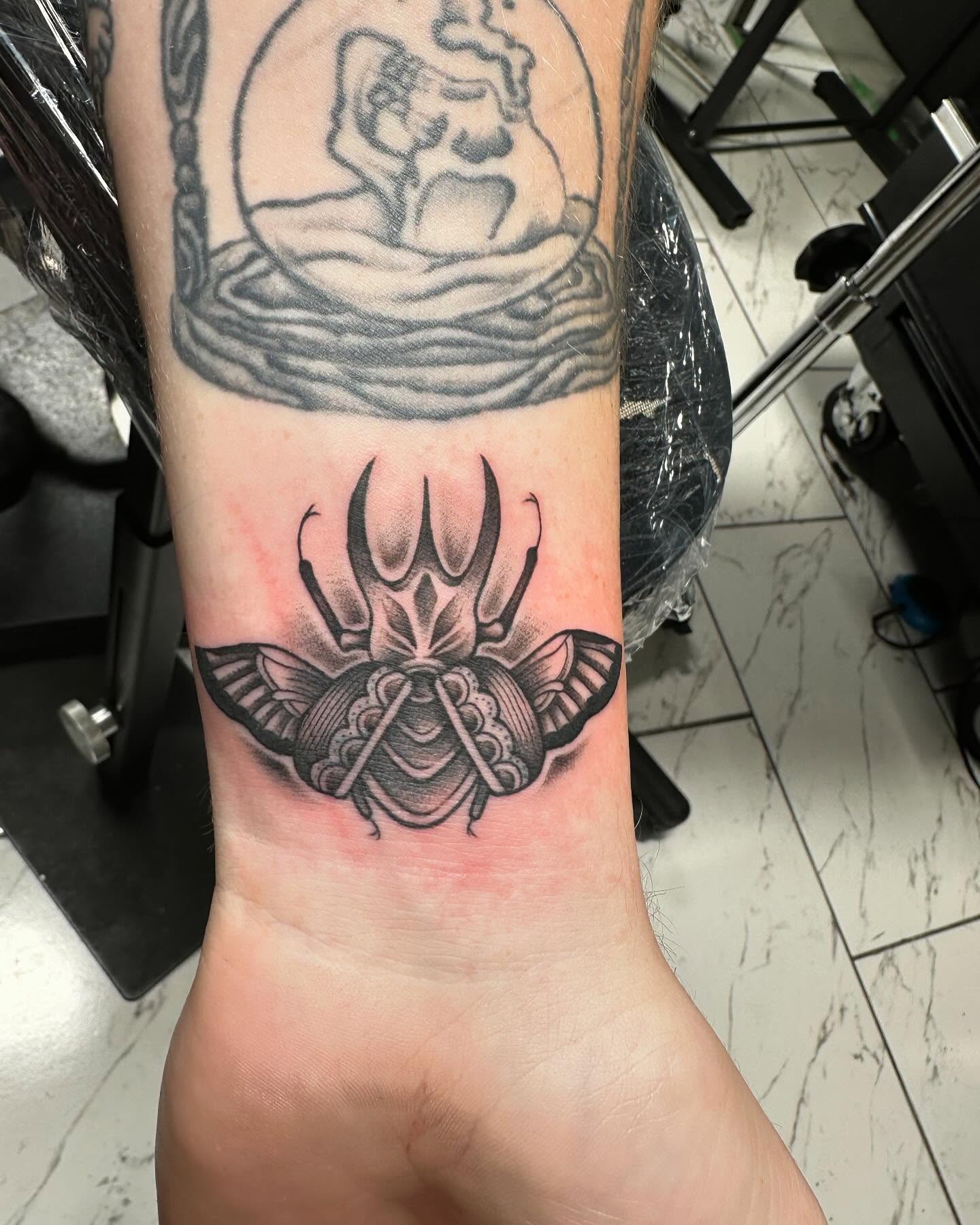 Scarab beetle black and grey tattoo on the forearm by Jan Xander