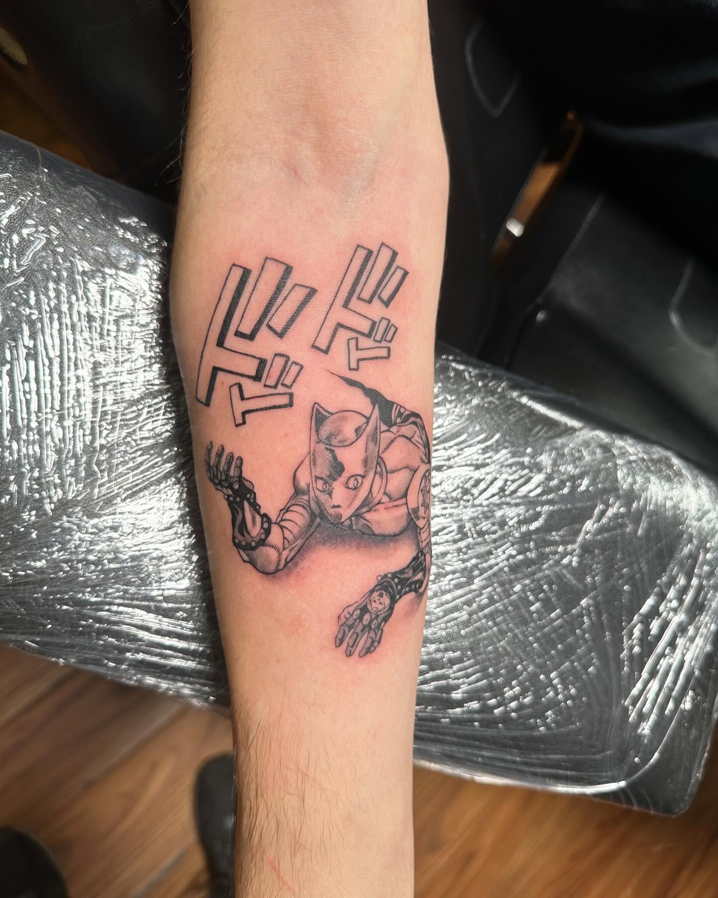Cat-like creature black and grey tattoo on the forearm by Jan Xander