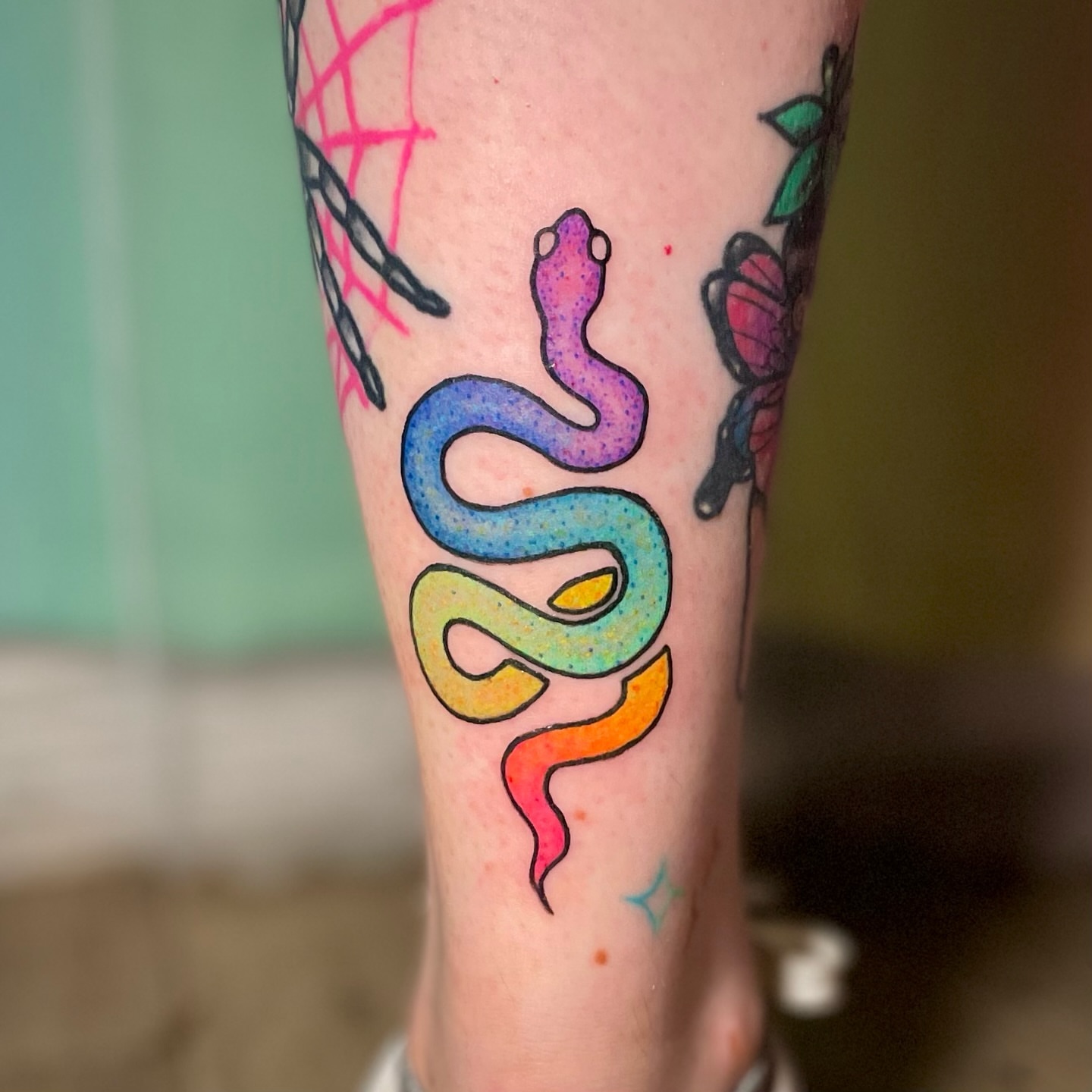 Rainbow snake dotwork tattoo on the forearm by Liv