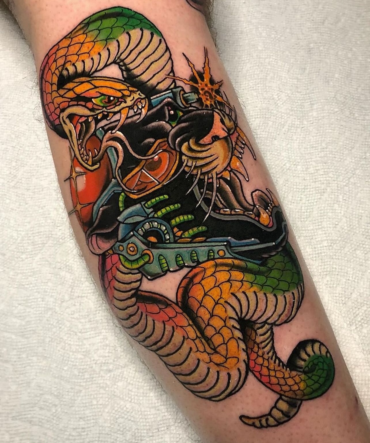 Snake and mechanical elements American traditional tattoo on the forearm by Jade Napier