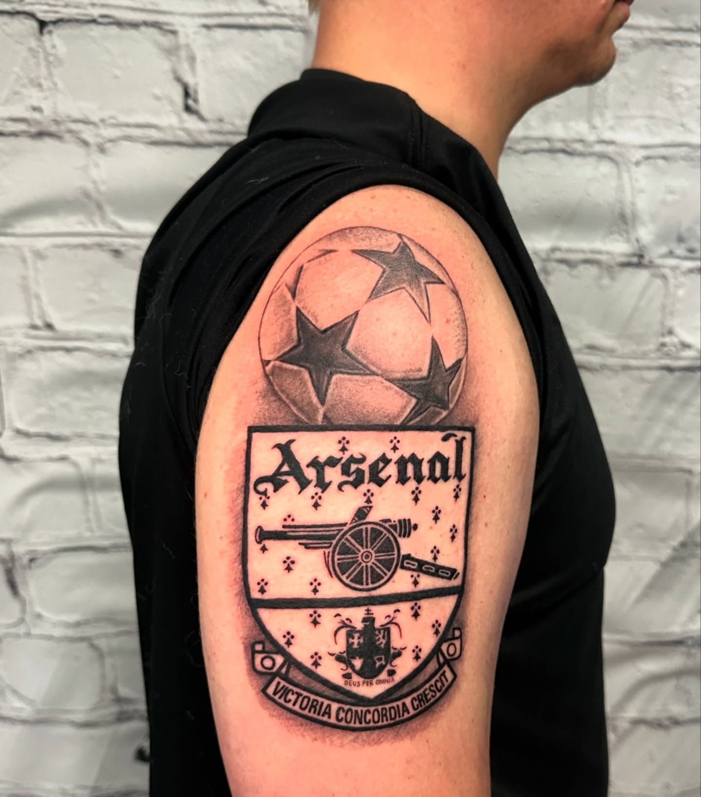 Arsenal crest black and grey tattoo on the shoulder by Stephen Hansen