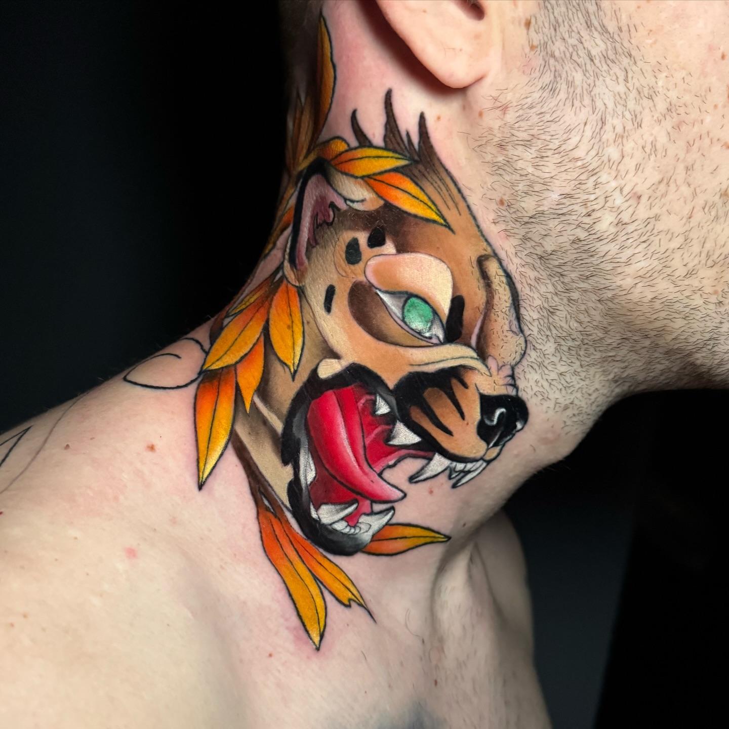 Animal head with leaves American traditional tattoo on the neck by Cristian Romero