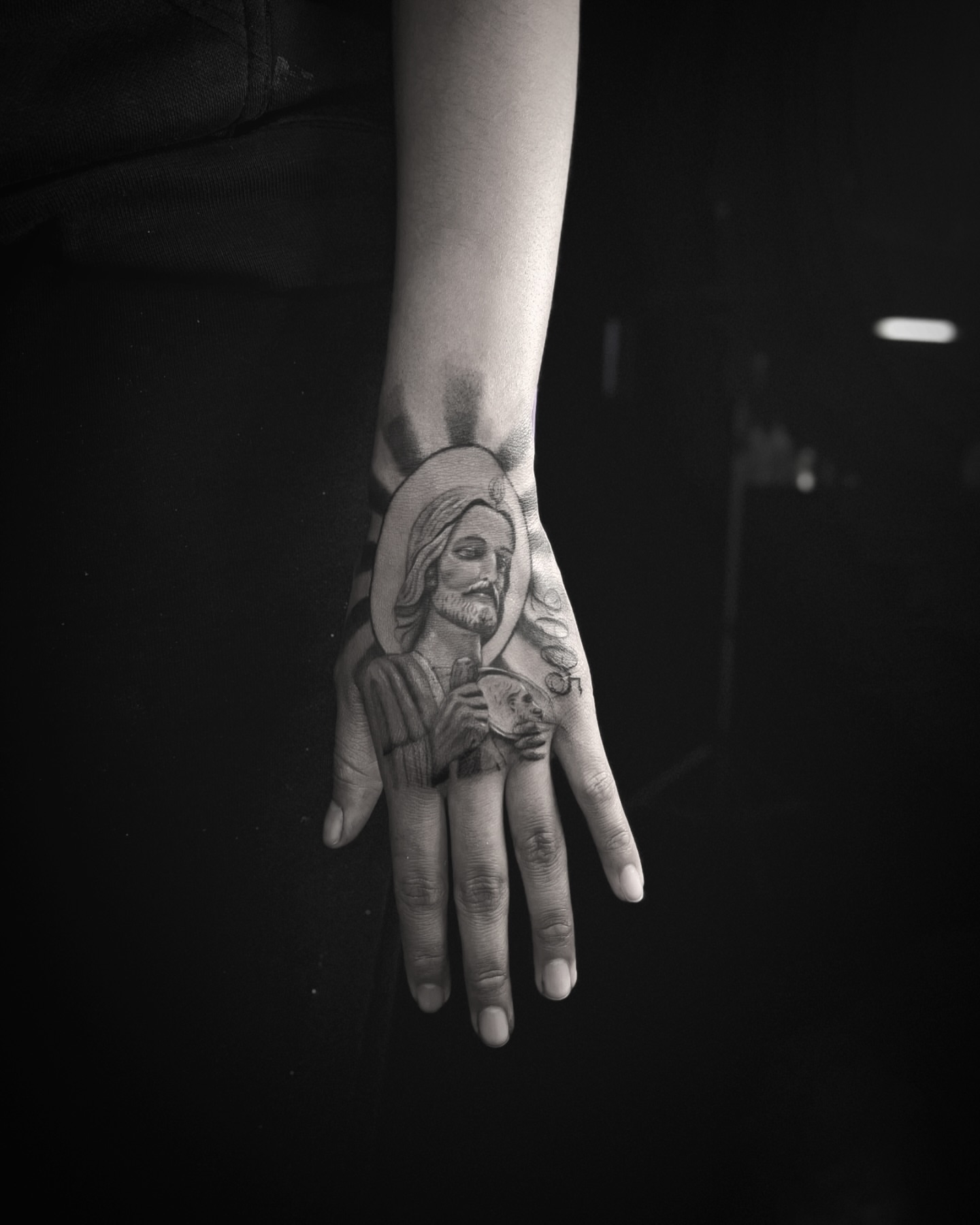 Religious figure black and grey tattoo on the hand by Romi Utah Tattoo