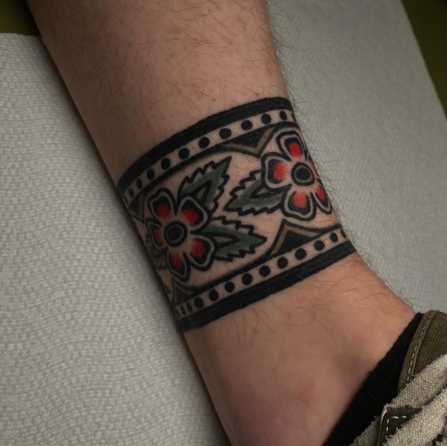 Floral band American traditional tattoo on the forearm by Erin Chambers