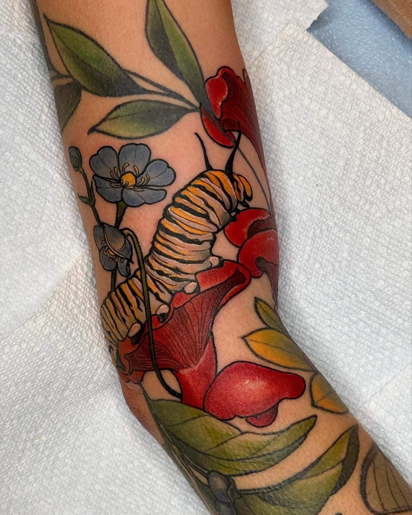 Monarch caterpillar and flowers American traditional tattoo on the forearm by Rachael Shelly