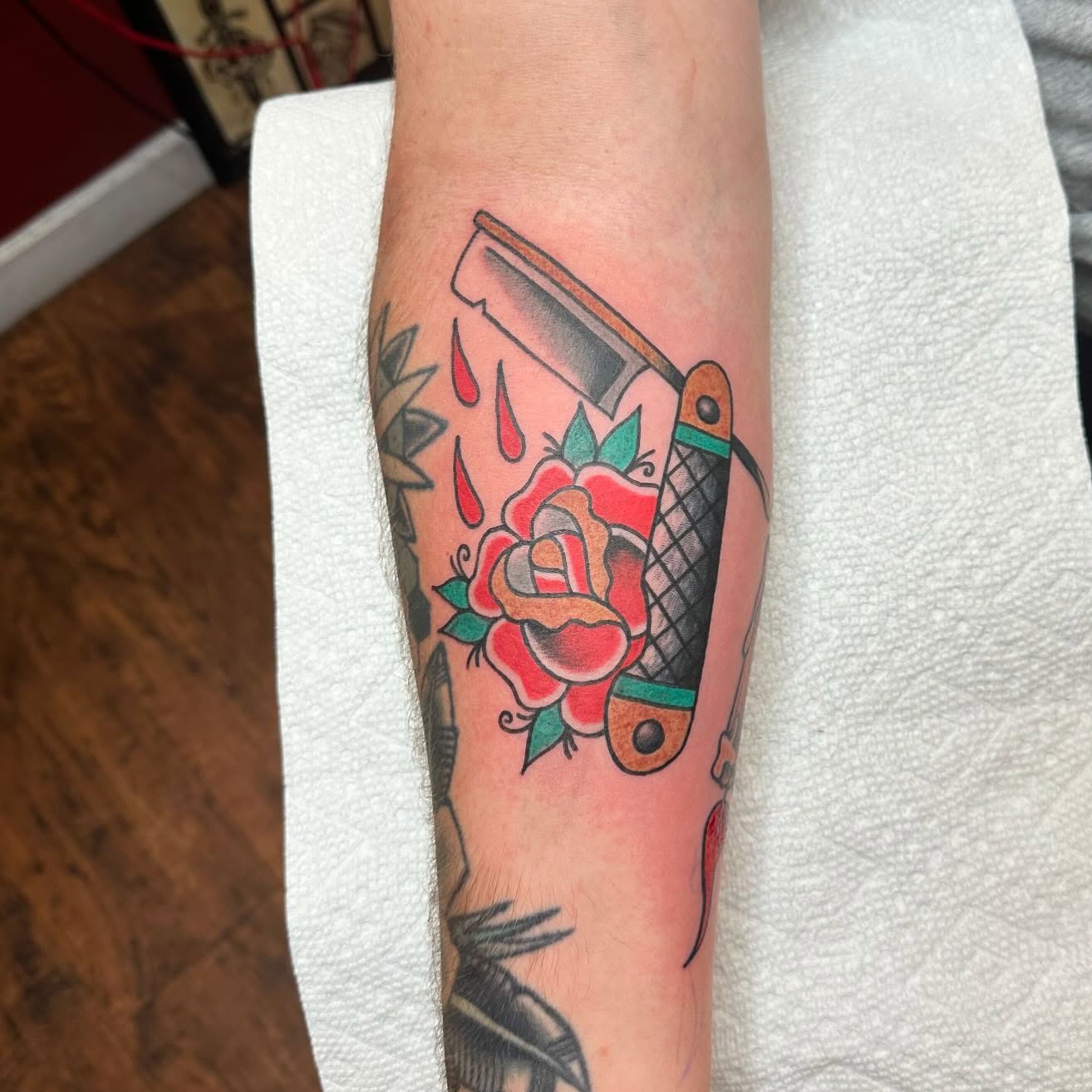 Rose and razor American traditional tattoo on the forearm by Jackie