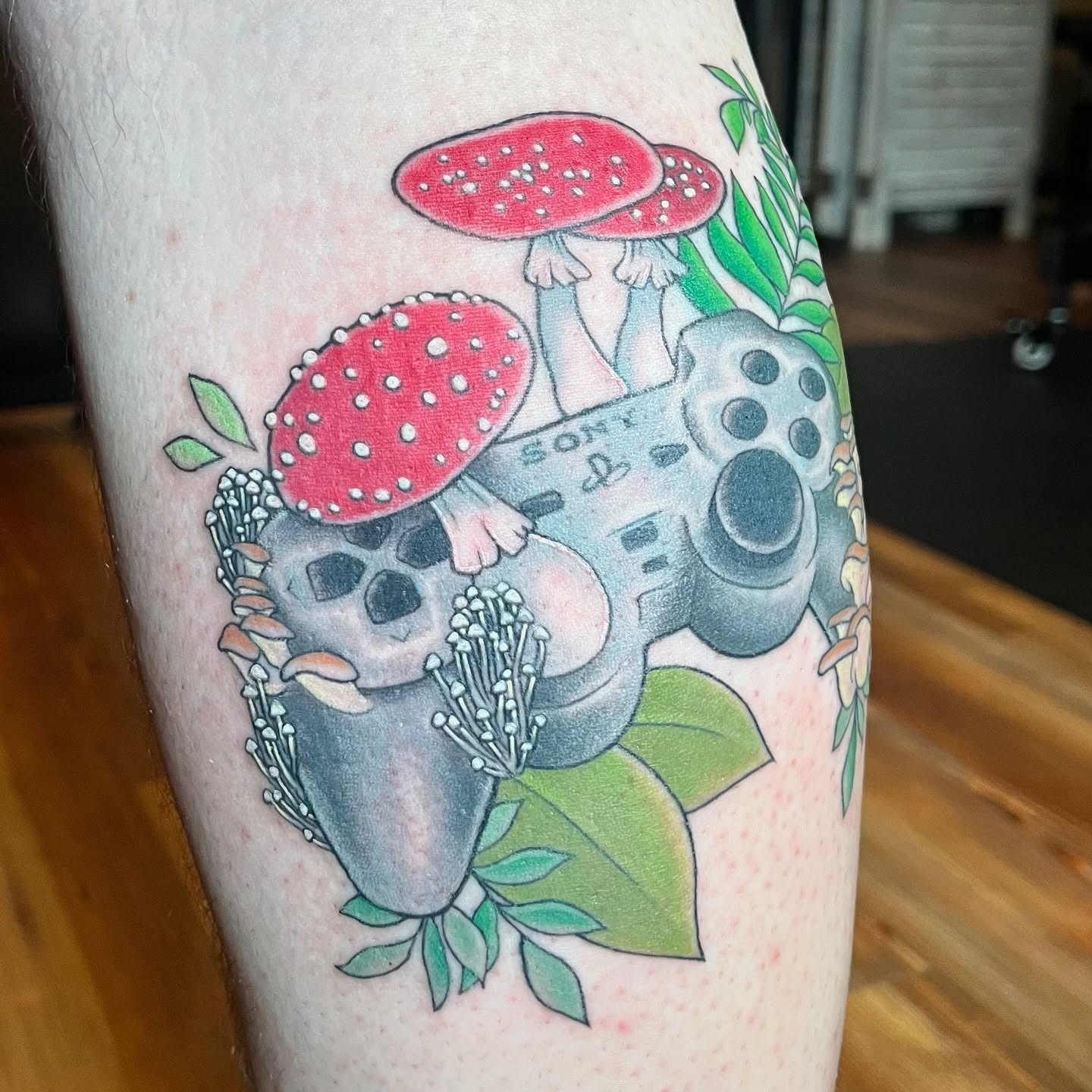 Video game controller with mushrooms dotwork tattoo on the forearm by Krystal ✨