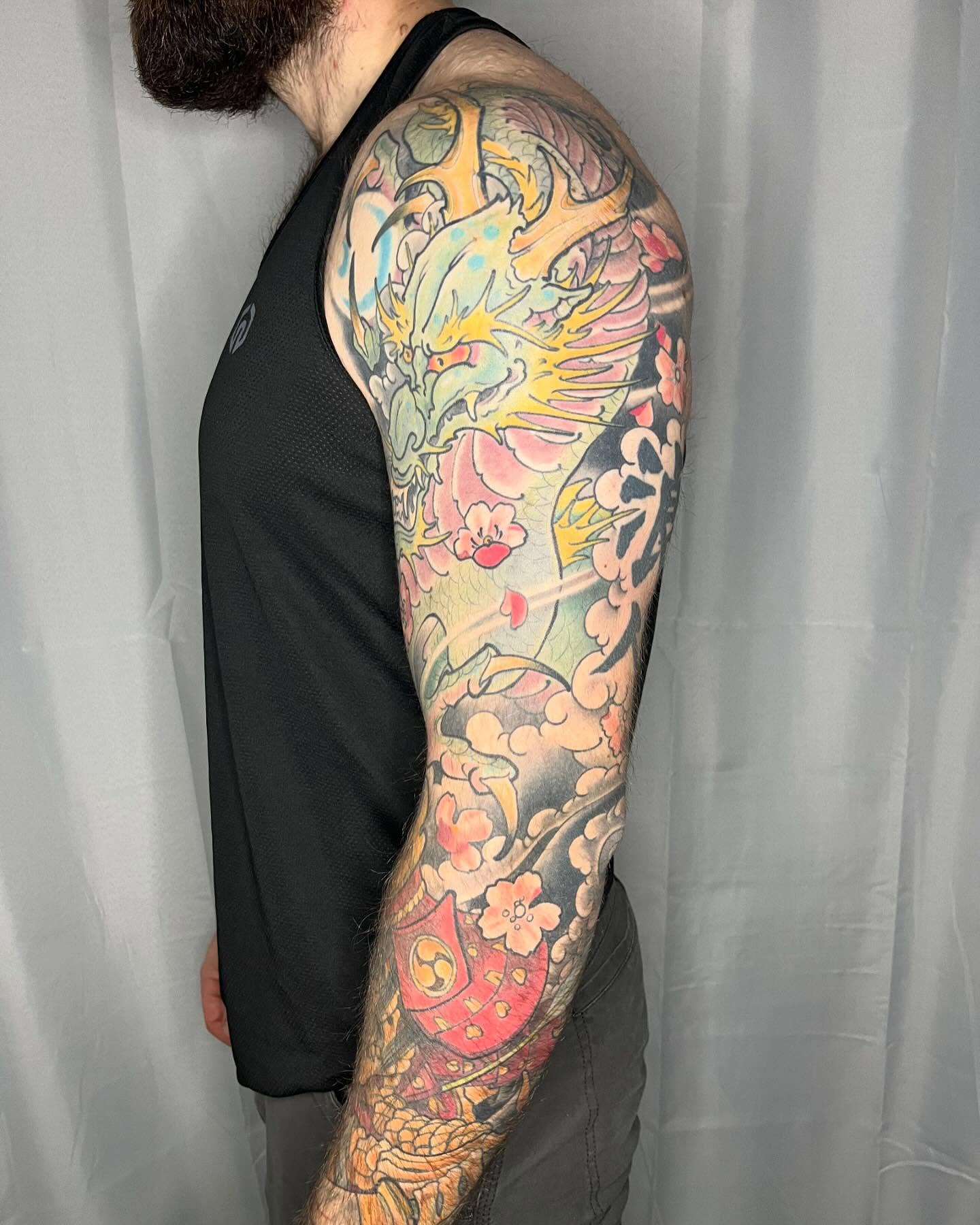 Phoenix and cherry blossoms japanese irezumi tattoo on the upper arm by biggstattoos