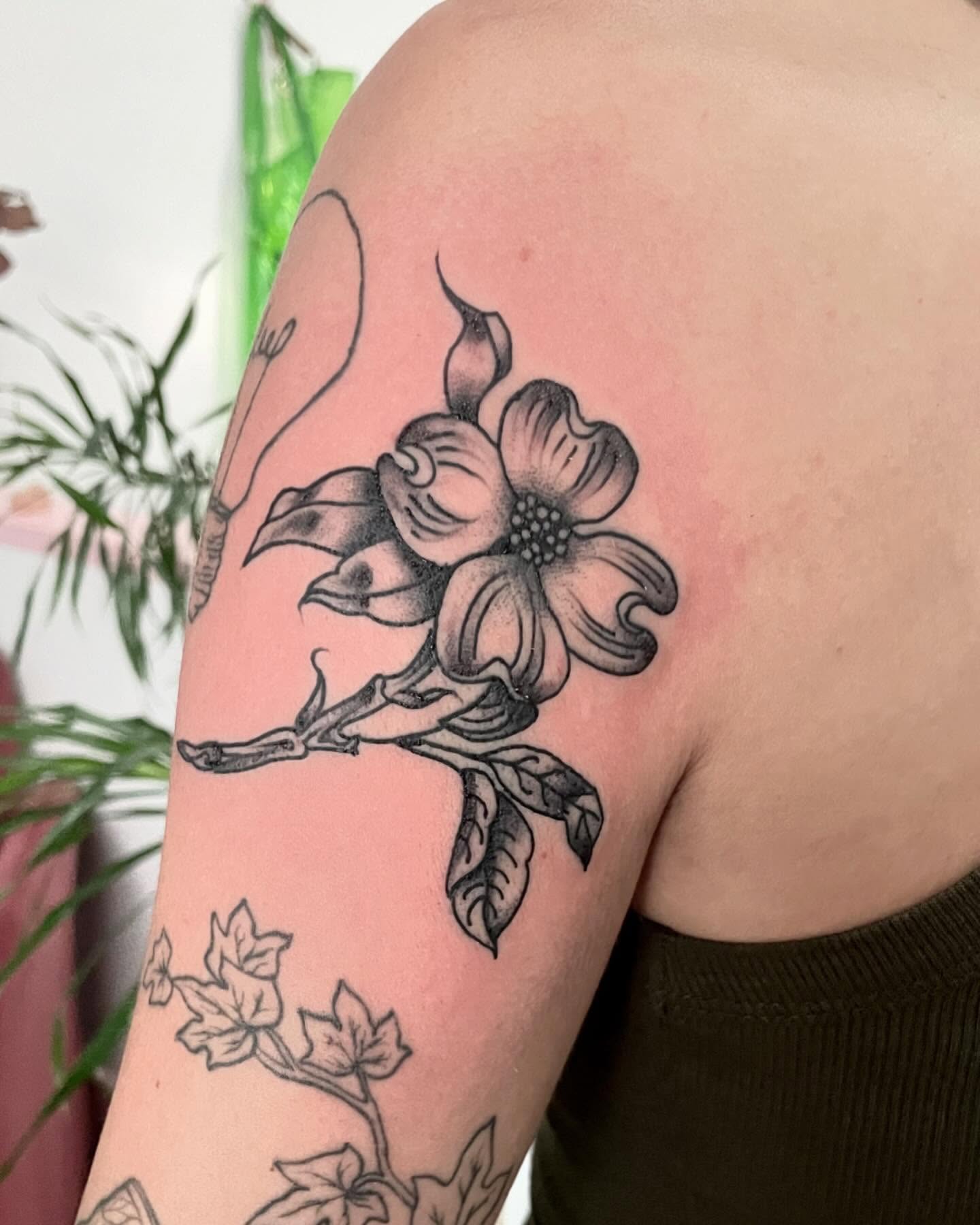 Flower black and grey tattoo on the upper arm by G. Clover ⚧︎, Chicago, Illinois
