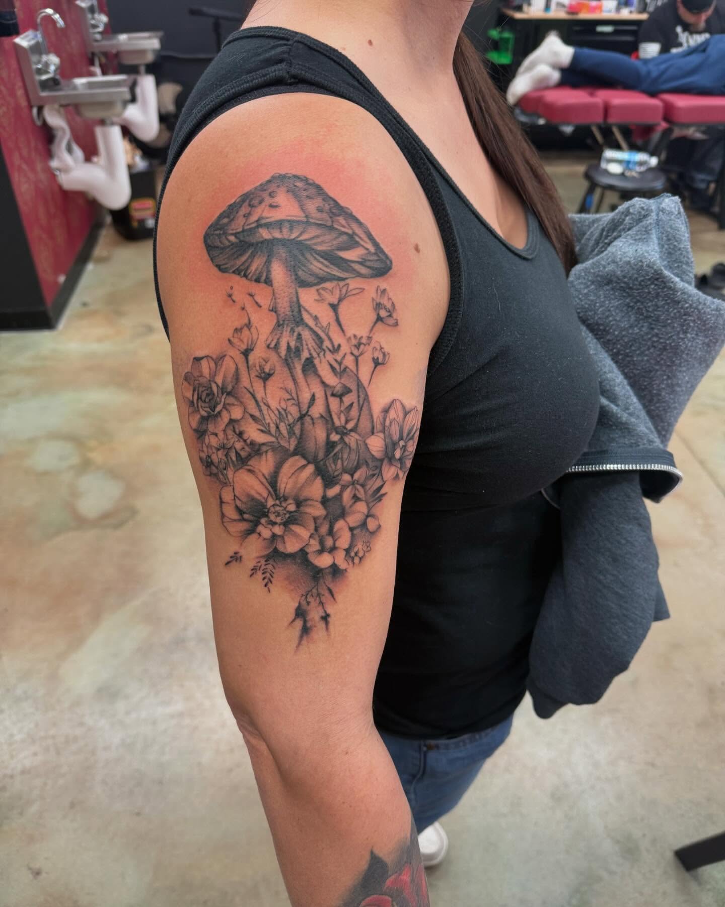 Mushroom and flowers realism tattoo on the upper arm by Shawn Cook