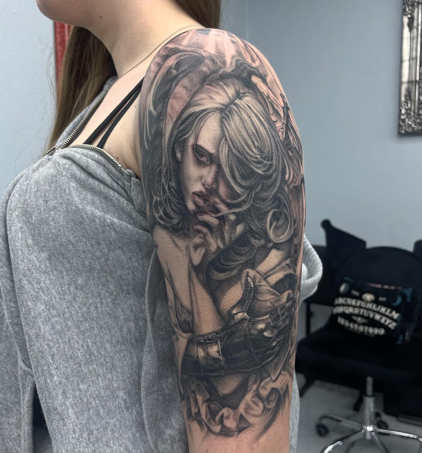 Woman with long hair realism tattoo on the upper arm by Austin Jones