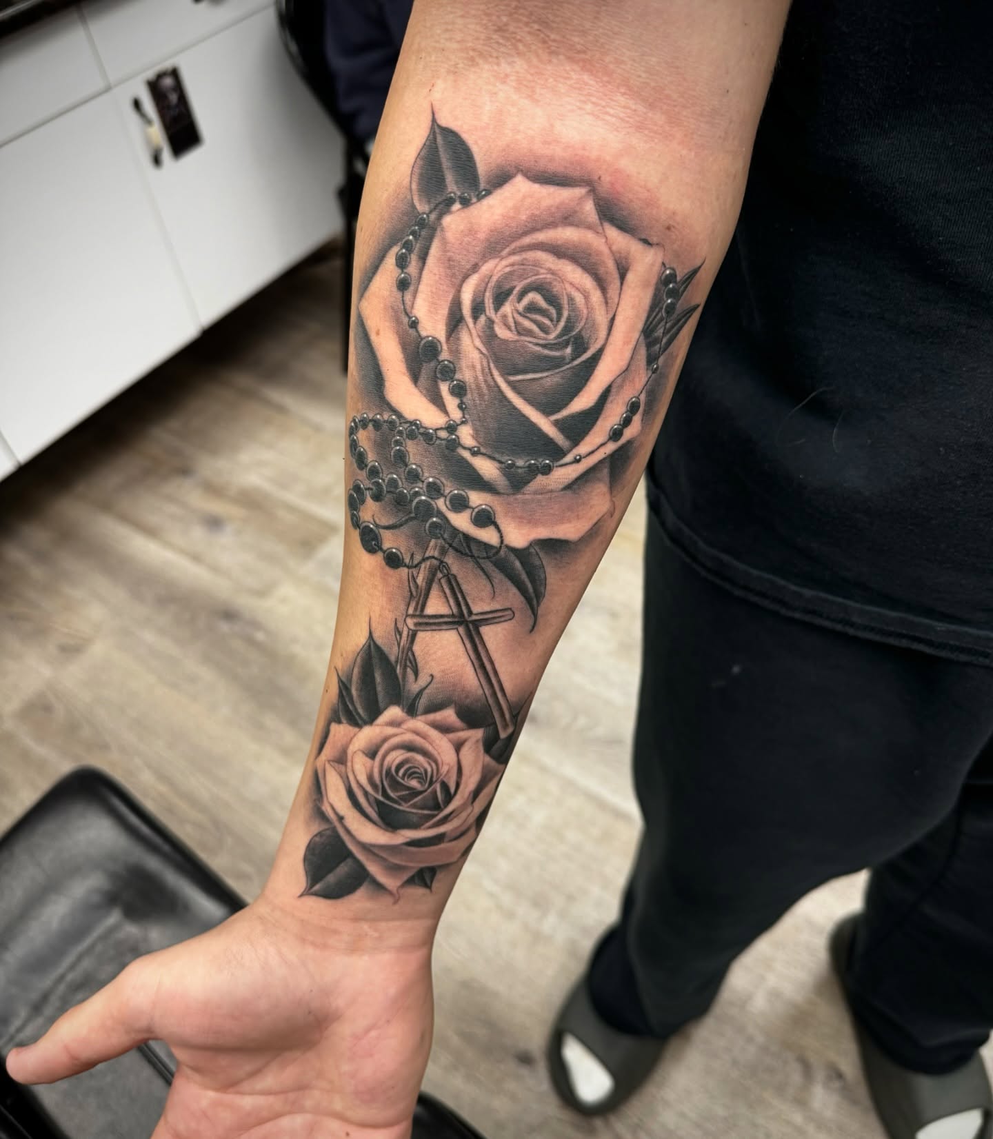 Roses and cross realism tattoo on the forearm by Mike Hudson