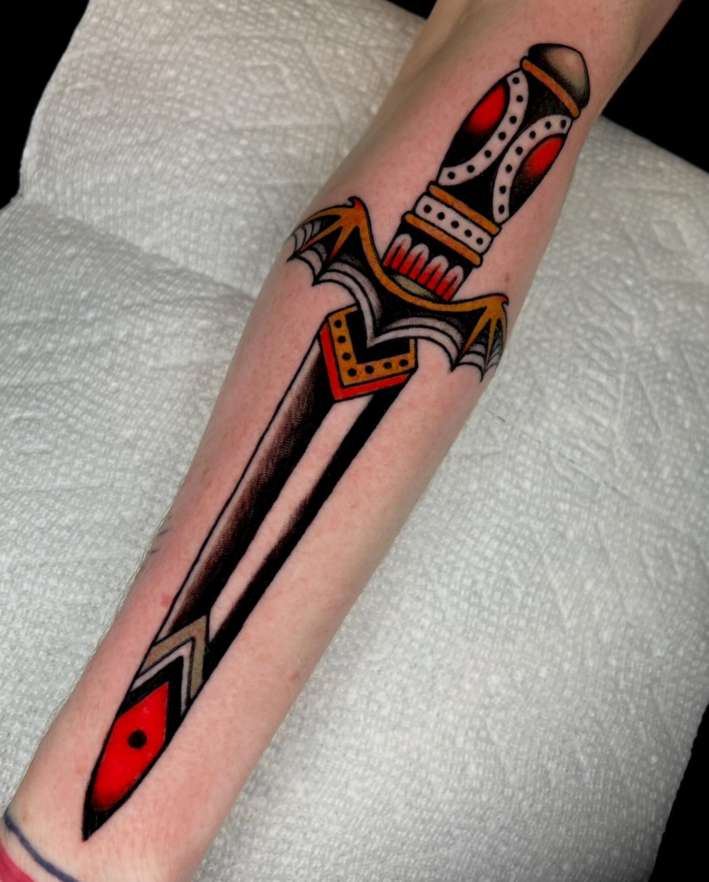 Sword American traditional tattoo on the forearm by Hailey Johnson