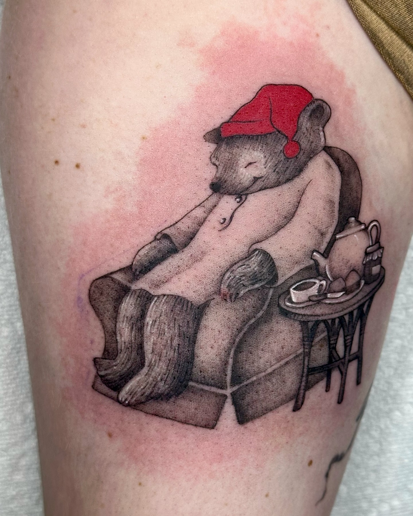 Teddy bear in Santa hat realism tattoo on the thigh by cora cupid