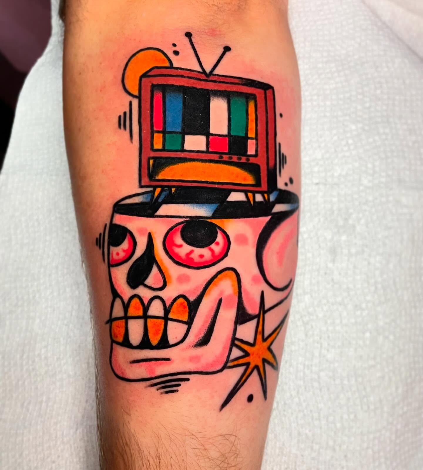 Skull with TV American traditional tattoo on the forearm by Jacob, Marion, Illinois