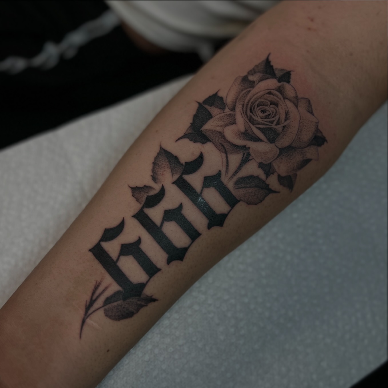Rose and name realism tattoo on the forearm by Amber