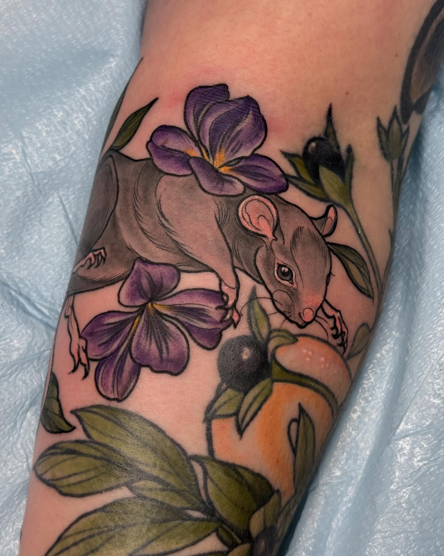 Rat and flowers realism tattoo on the forearm by Rachael Shelly