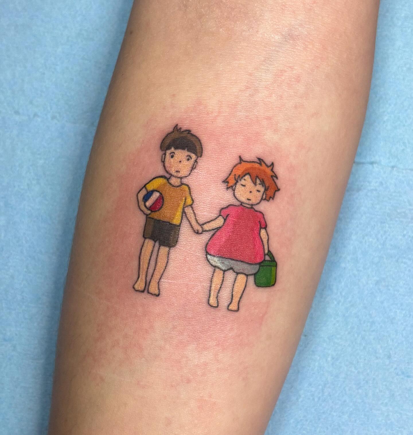 Children playing anime tattoo on the forearm by Katelyn Spence