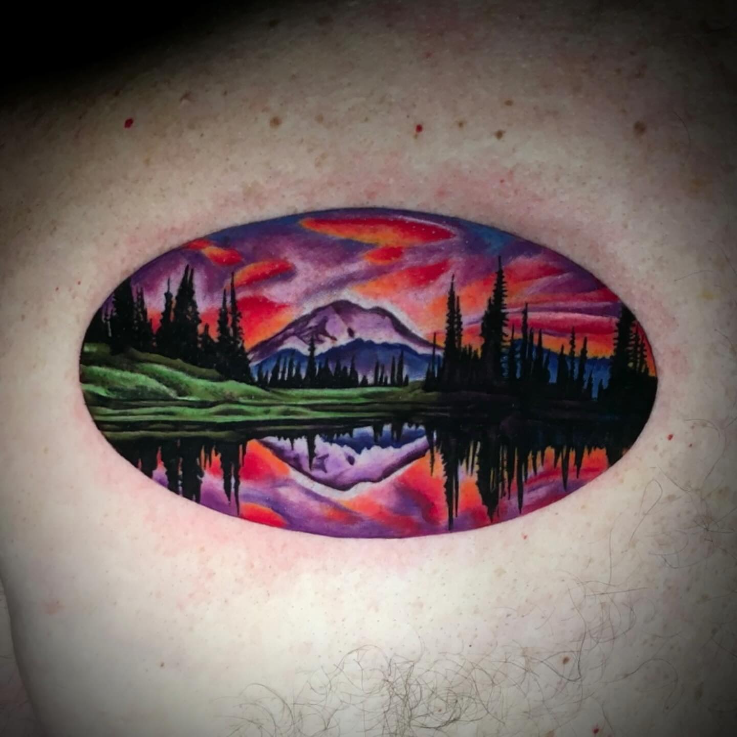 Mountain landscape watercolor tattoo on the chest by Ray Marie