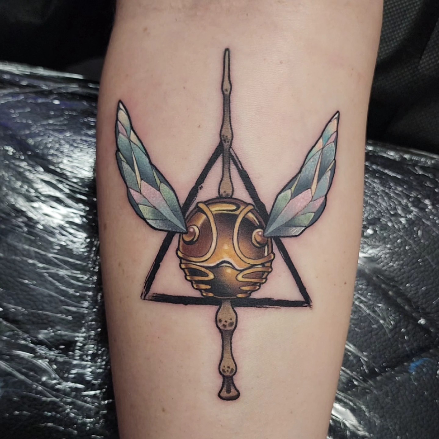 Golden snitch geometric tattoo on the forearm by Joanna Nguyen ♈