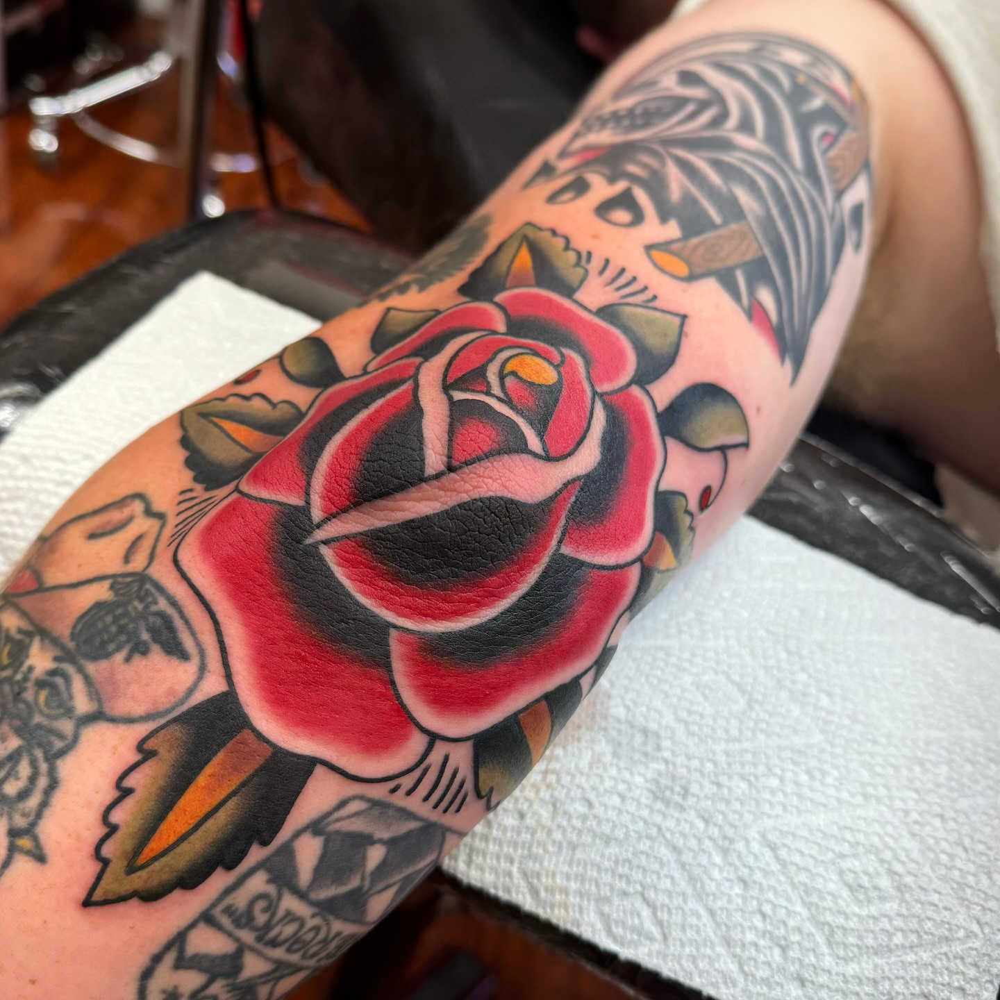 Red rose American traditional tattoo on the forearm by Rogelio Robles