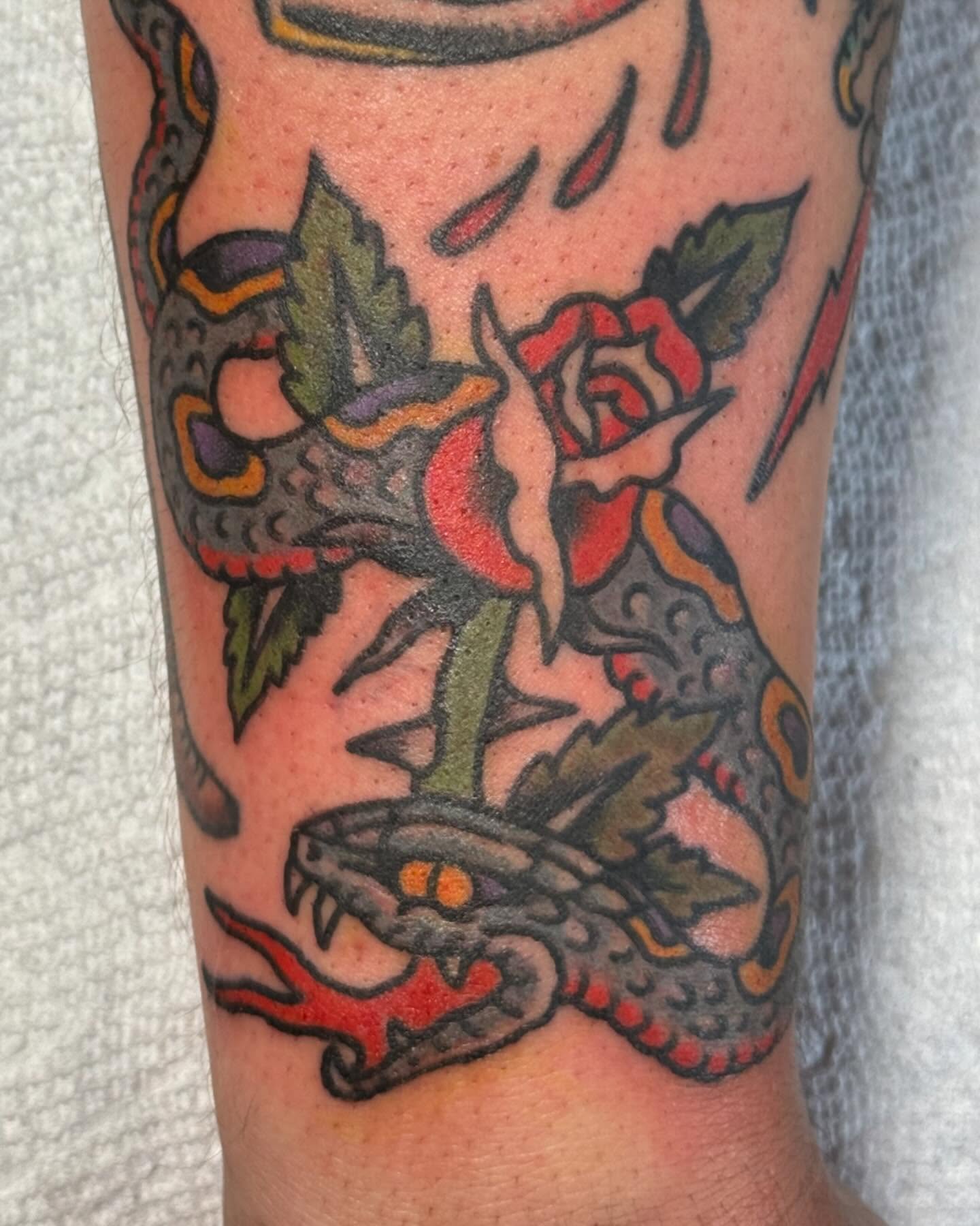 Snake and rose American traditional tattoo on the forearm by Jesse Swanson, Santa Rosa, California