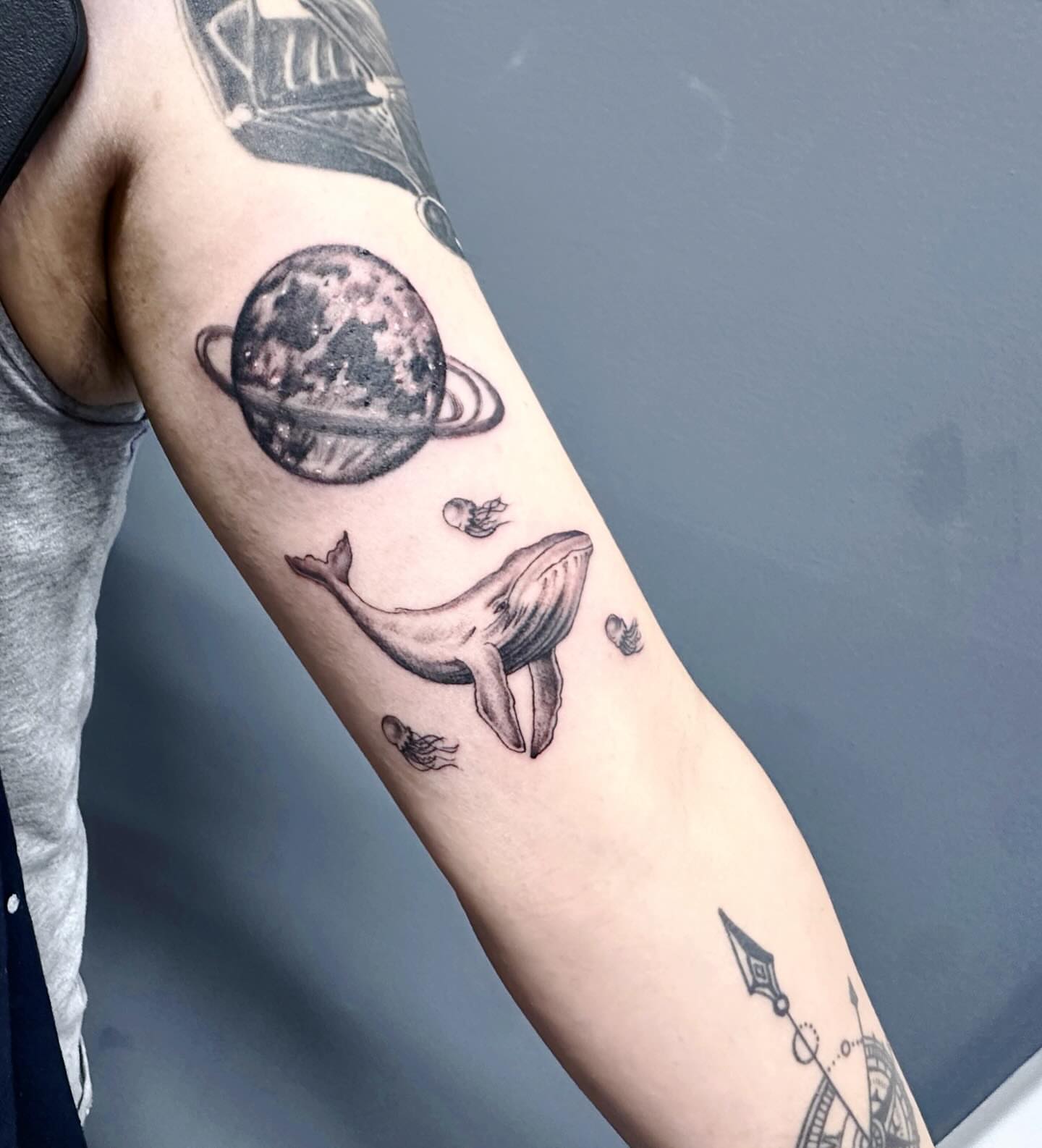 Whale and planet black and grey tattoo on the forearm by mia's tattoo, Los Angeles, California