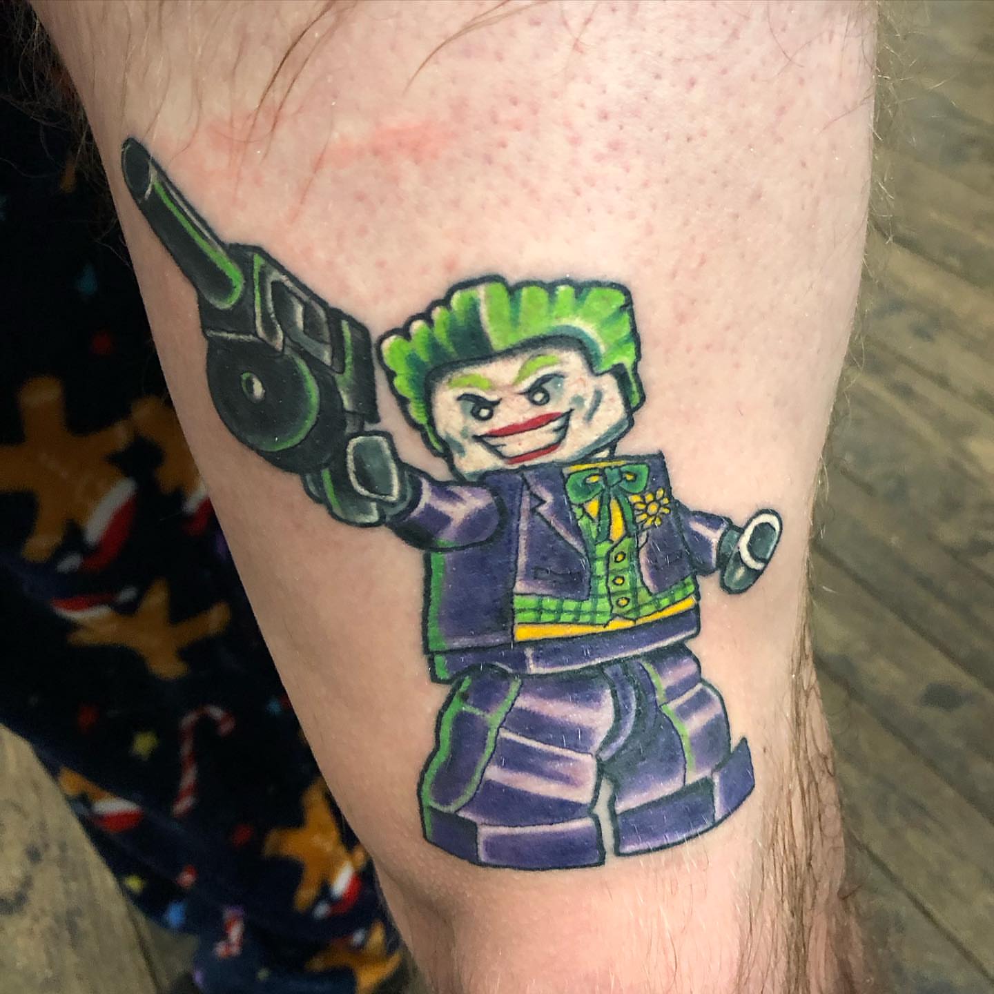 Joker lego minifigure illustrative tattoo on the forearm by A.W.