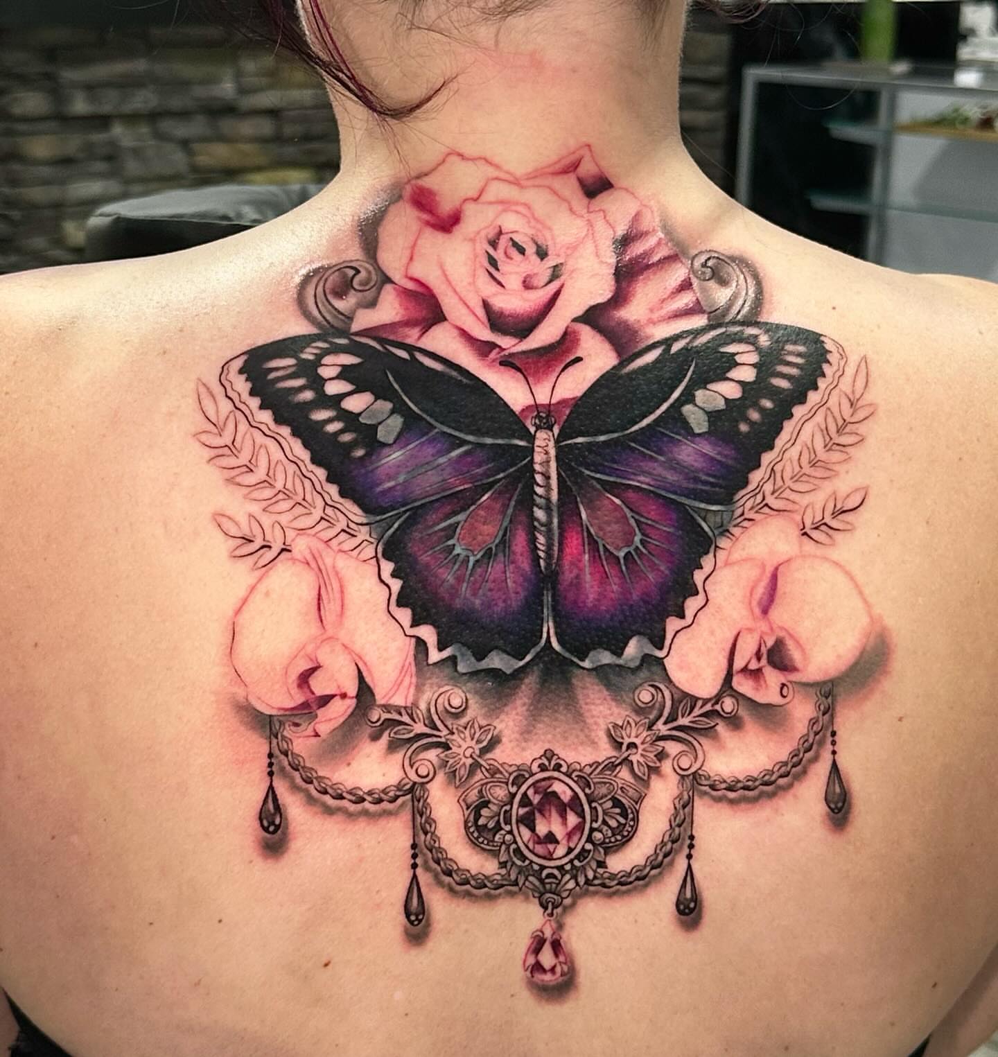 Butterfly and rose realism tattoo on the back by Chynna J El-Ayazra