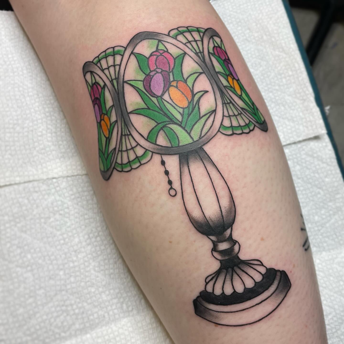 Lamp with floral design new school tattoo on the forearm by Michelle