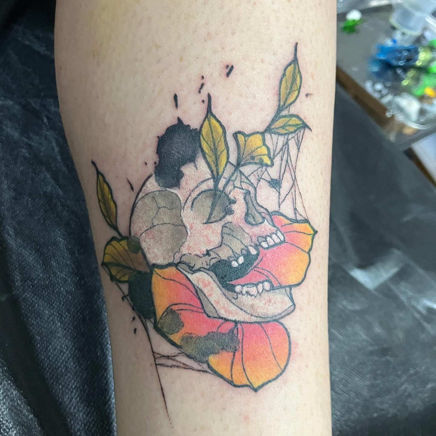 Skull and flower new school tattoo on the forearm by Hot Dawg