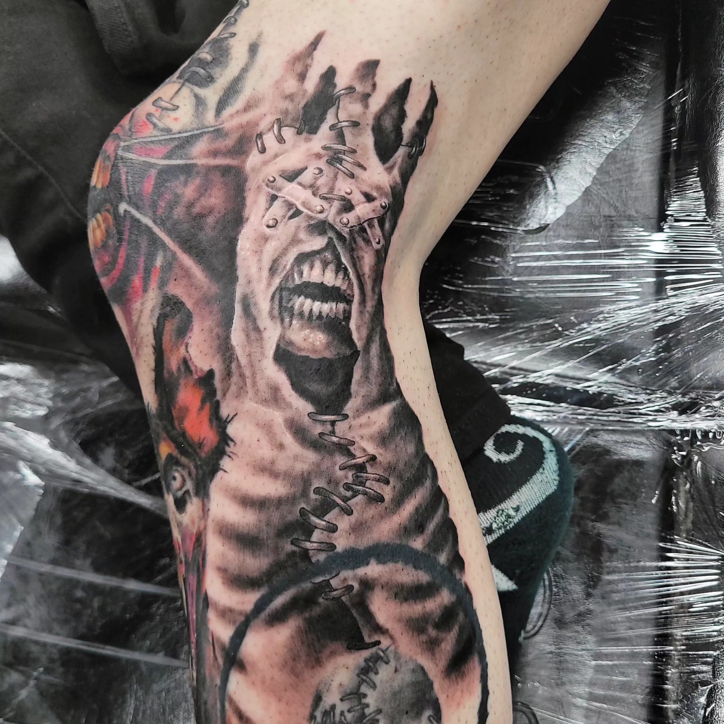 Horror creature dark realism tattoo on the leg by Jentrey McCausland
