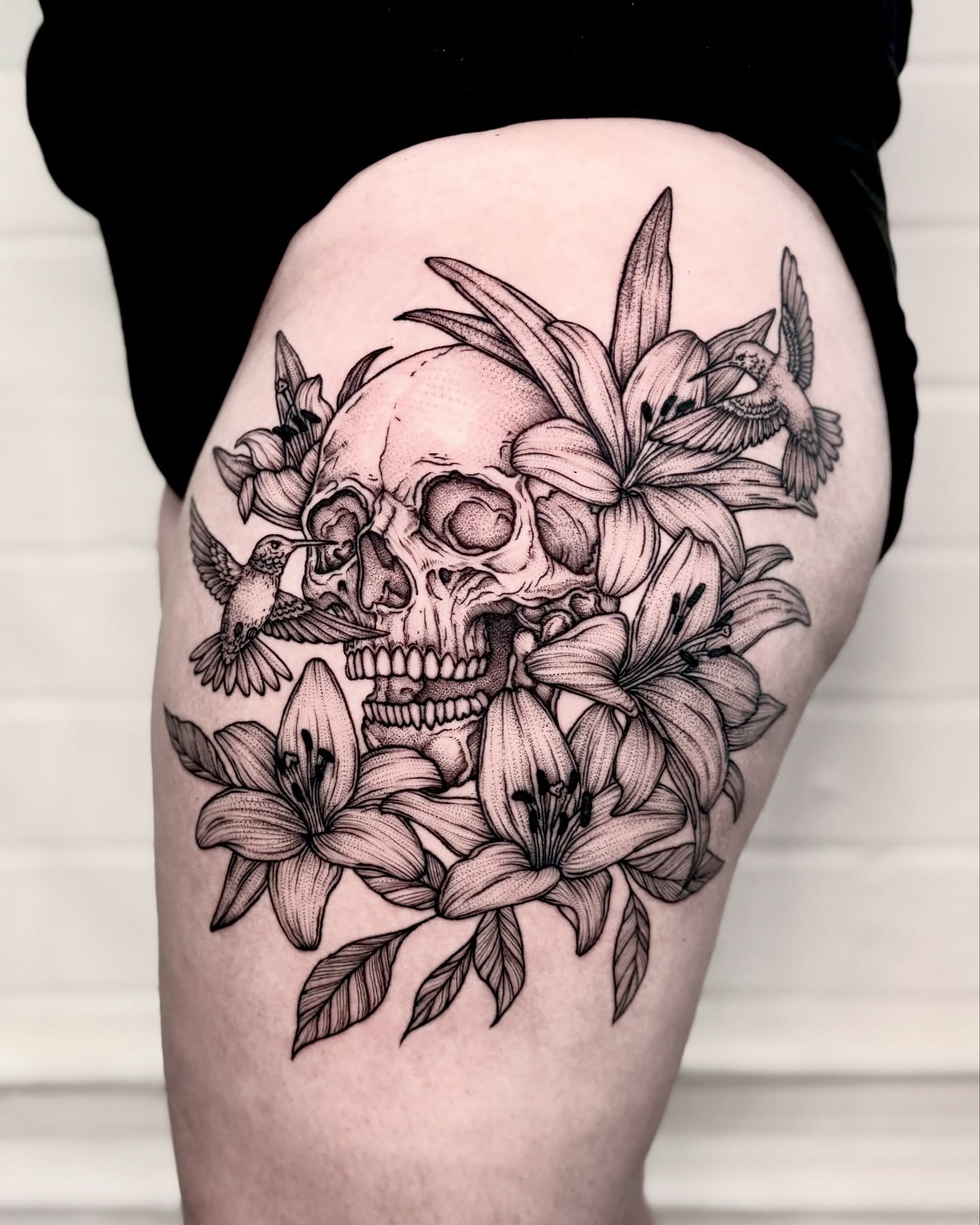 Skull and lilies realism tattoo on the thigh by Alex Shakuto Tattoo